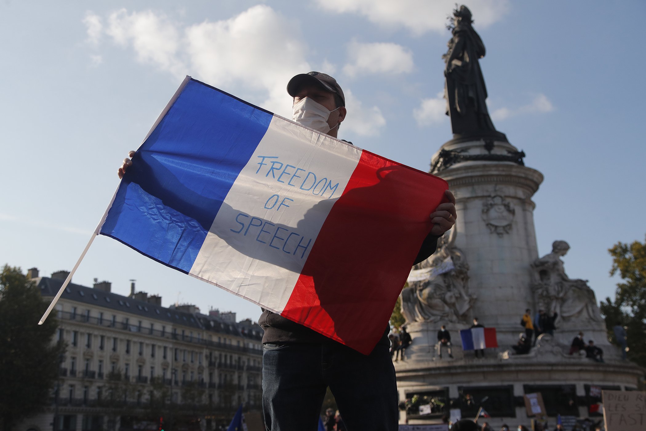 A demonstrator holds a French flag with the slogan "Freedom of Speech" during a demonstration on Oct. 18, 2020 in Paris.