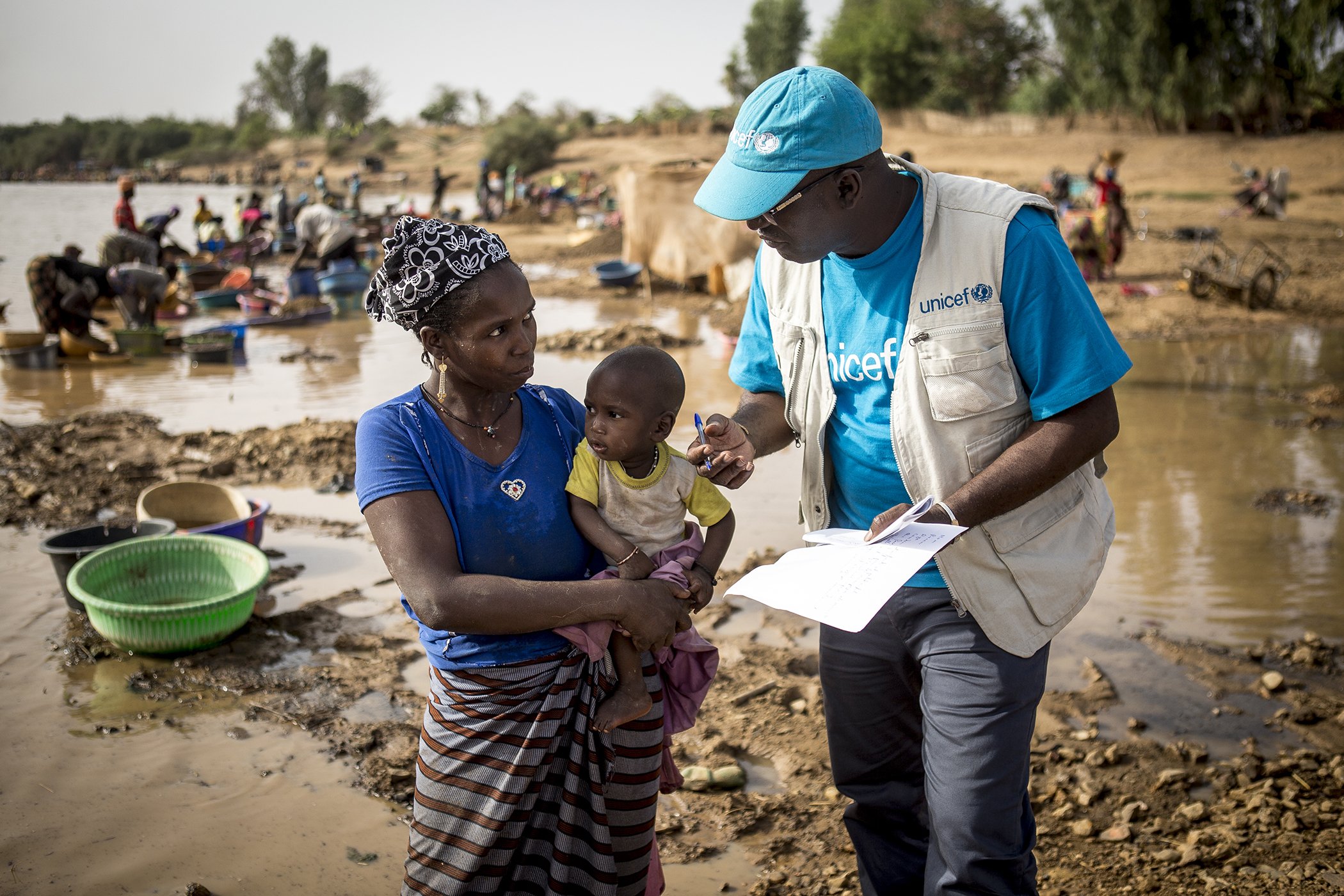 Abdoulaye Konate, an immunization officer at UNICEF’s field office in Kayes, Mali, talks with Ramata Diallo, 40, on the importance of vaccinating her youngest child, Hachime, 11 months, who has never been vaccinated, on March 20, 2019.