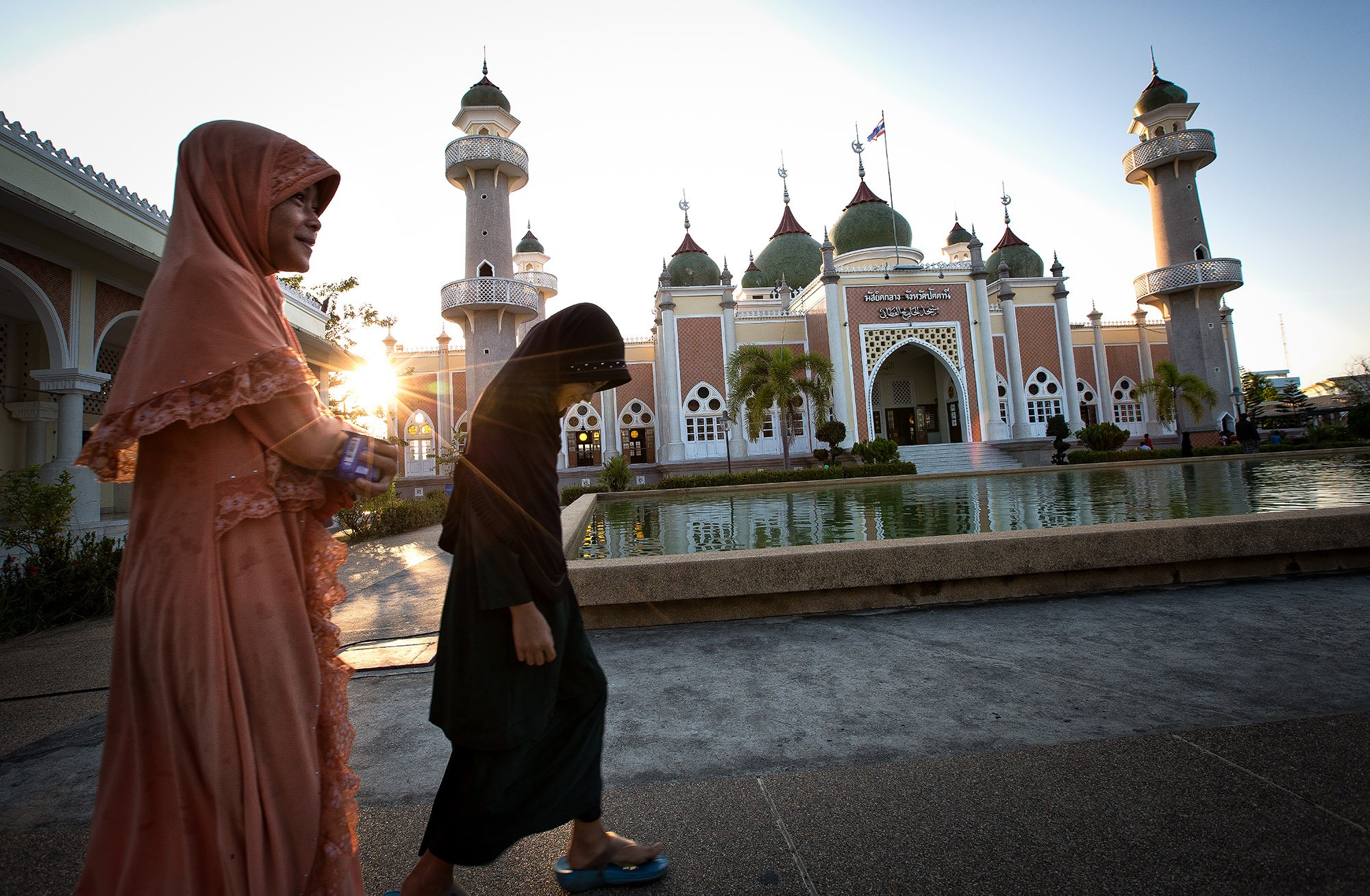 Thai girls walk past Pattani Central Mosque before the evening prayers. Women in the region are encouraged to cut their daughters under the assumption that it will control their sexual urges in adulthood and make them “clean."