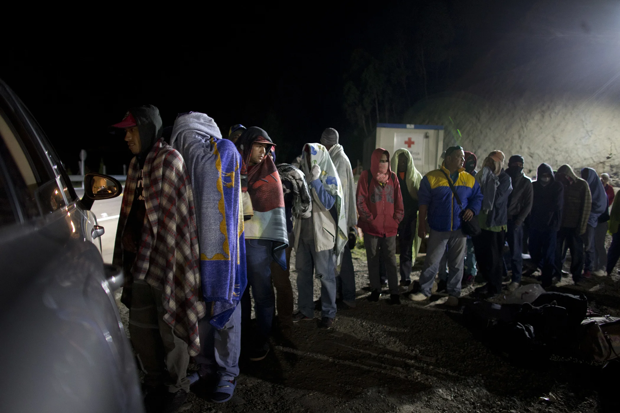 Venezuelan migrants line up for free bread and coffee, donated by a Colombian family from their car, at a gas station in Pamplona, Colombia on Aug. 31, 2018. Millions have fled Venezuela's deadly shortages and spiraling hyperinflation.