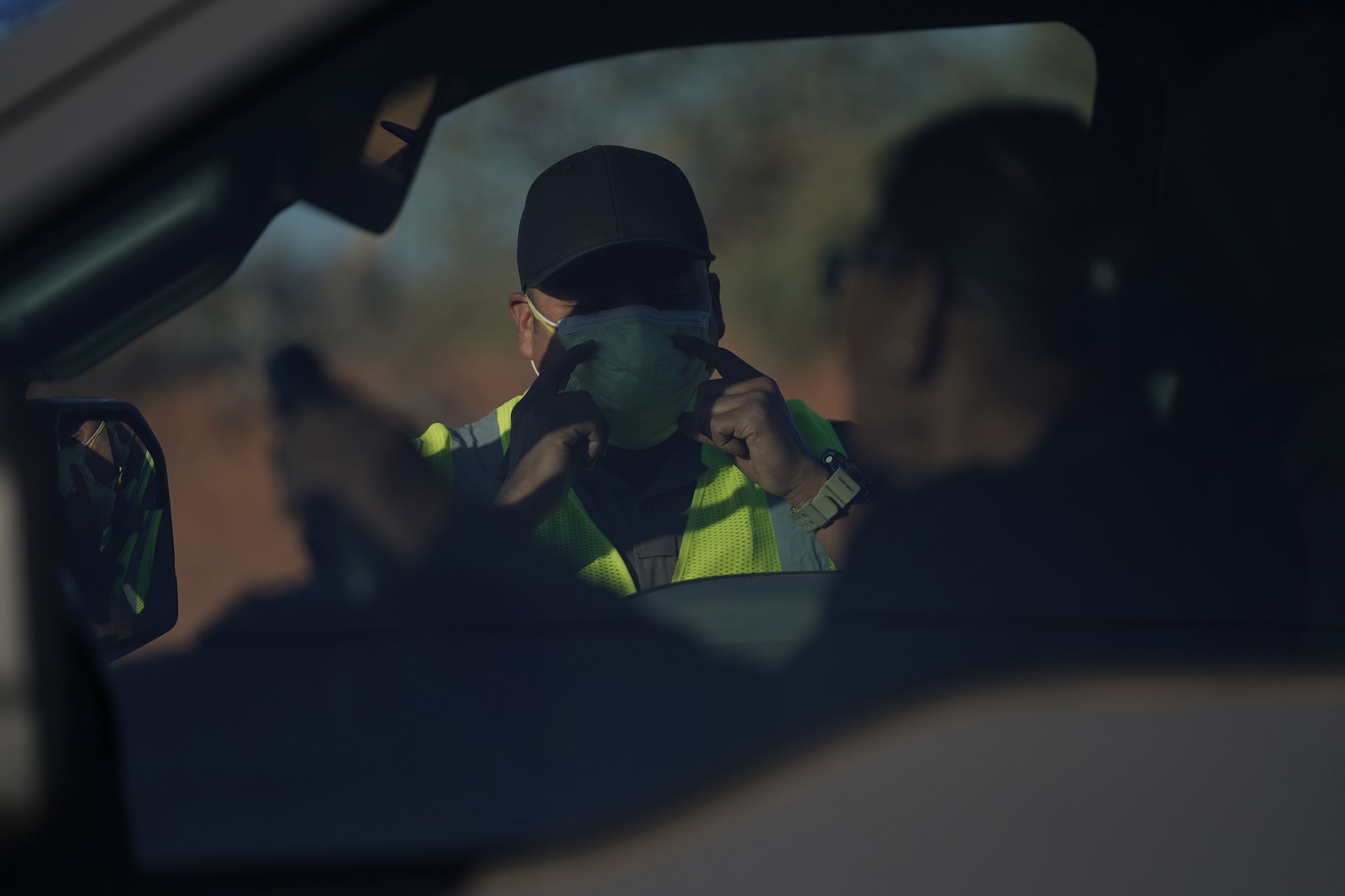 An officer with the Navajo Nation Police talks to a driver at a roadblock in Tuba City, Ariz., on the Navajo reservation on April 22, 2020. The roadblock was to inform residents of evening and weekend curfews, hand washing, and wearing a face mask.