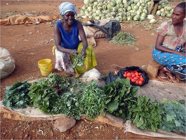 Woman showing her vegetable produce in Uganda