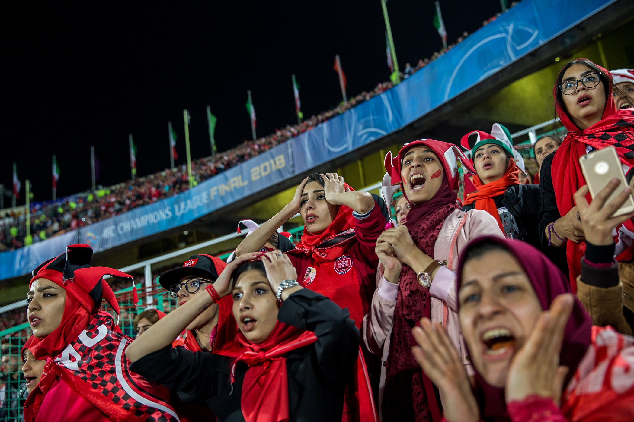 Crying for Freedom: Women follow the match from a separate stand, Azadi Stadium, Tehran, Nov. 10, 2018. 
In Iran, female fans are banned from entering football stadiums to watch the nation’s most popular sport. Nominated in the Sports Stories category.