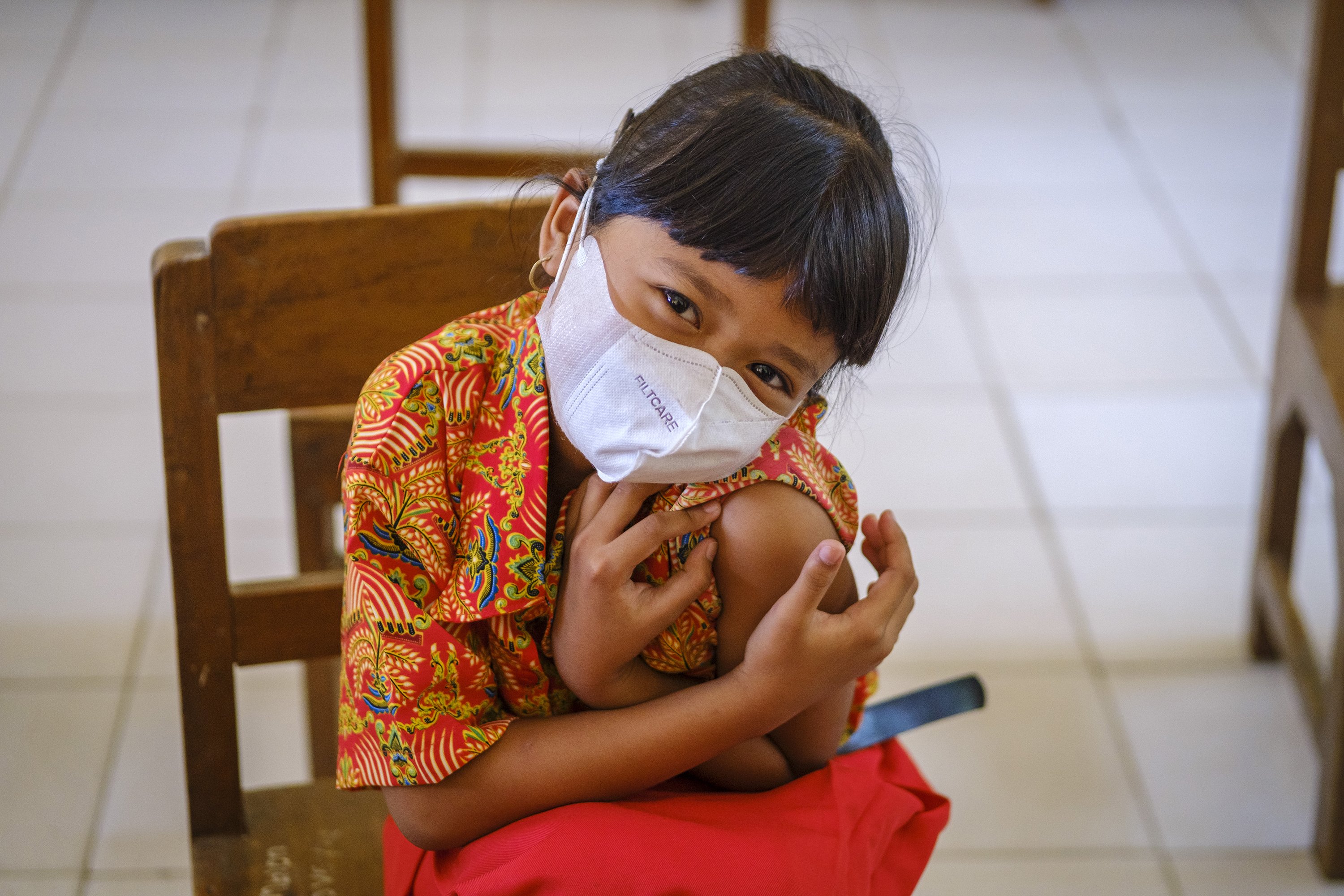 A second-grade student rolls up her sleeve to receive a dose of the measles and rubella (MR) vaccines at Kroyo Elementary School in Sragen, Central Java Province, Indonesia on Nov. 24, 2021.