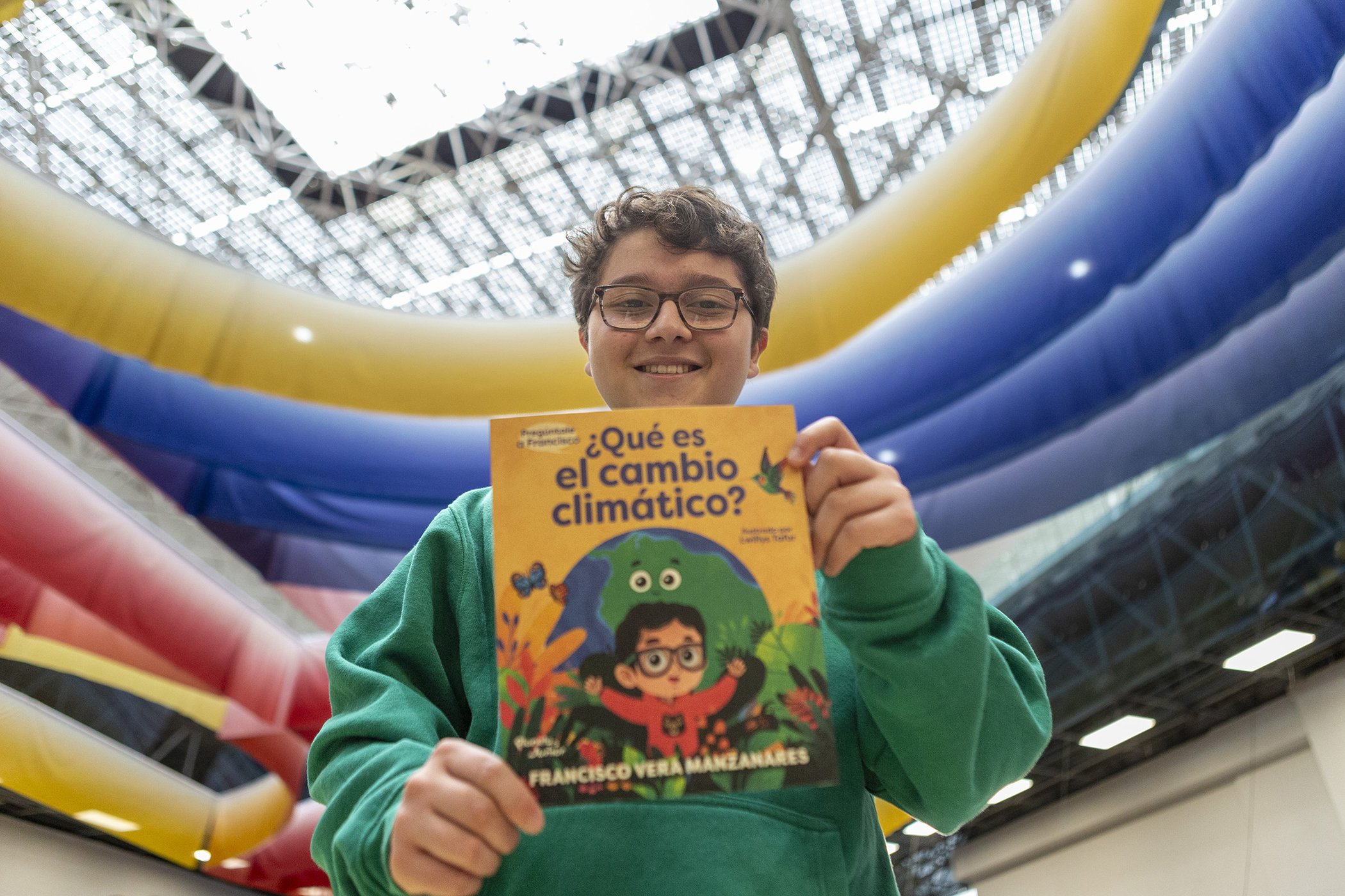 Francisco Vera sostiene su libro "Pregúntale a Francisco: ¿Qué es el cambio climático?", ilustrado por Lwillys Tafur y publicado por Planeta.