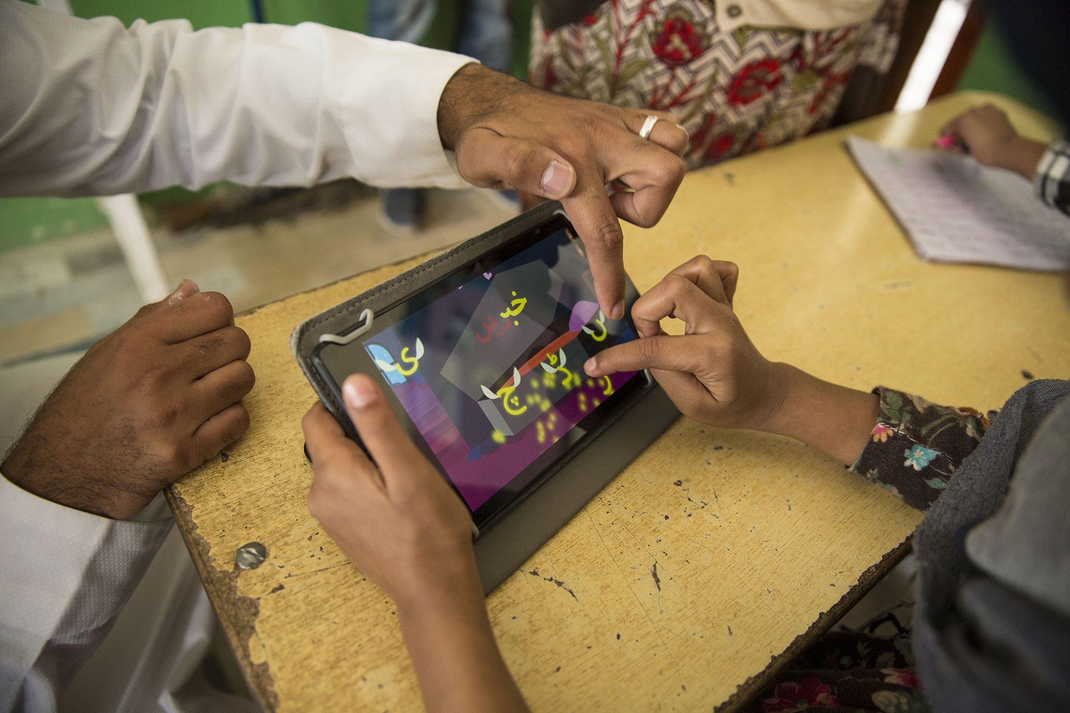 Haroon Yasin helps a student with the Taleemabad app at the Saya School in Islamabad, Pakistan on Oct. 9, 2019.