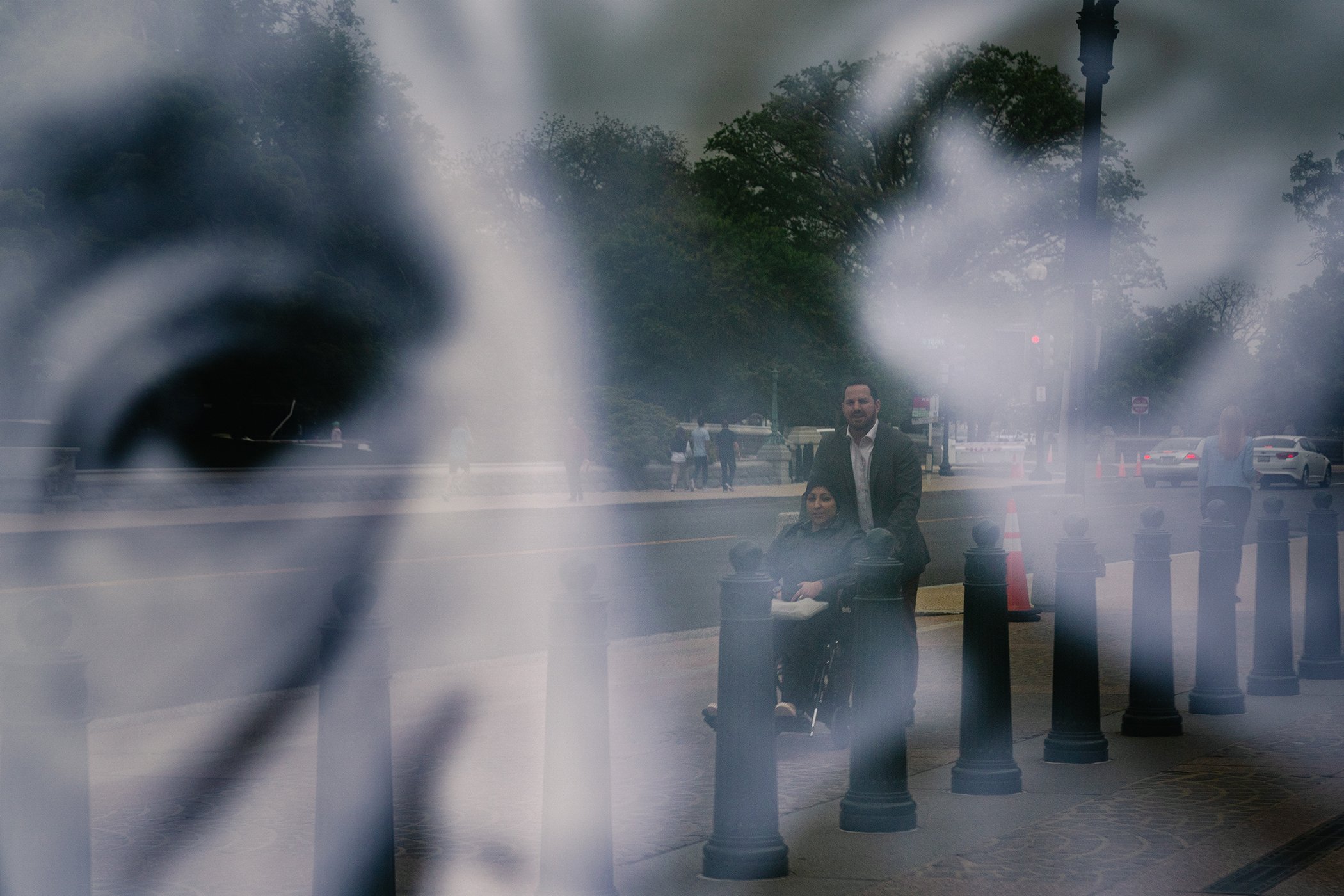 A reflection of Seth Binder, Director of Advocacy at Project on Middle East Democracy, pushing Bahraini human rights activist Maryam Al-Khawaja in a wheelchair is seen as they tour around near the Capitol Hill in Washington, DC on May 5, 2022.