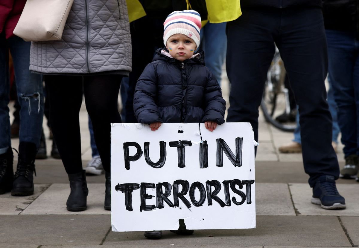 A very young protester holds a placard up during a protest in Trafalgar Square in London, UK.