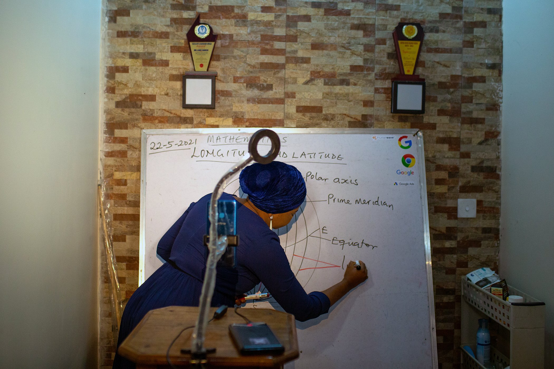 Basirat Ajayi uses her white board to explain a lesson in an online video for one of her classes on May 22, 2021 in Lagos, Nigeria.