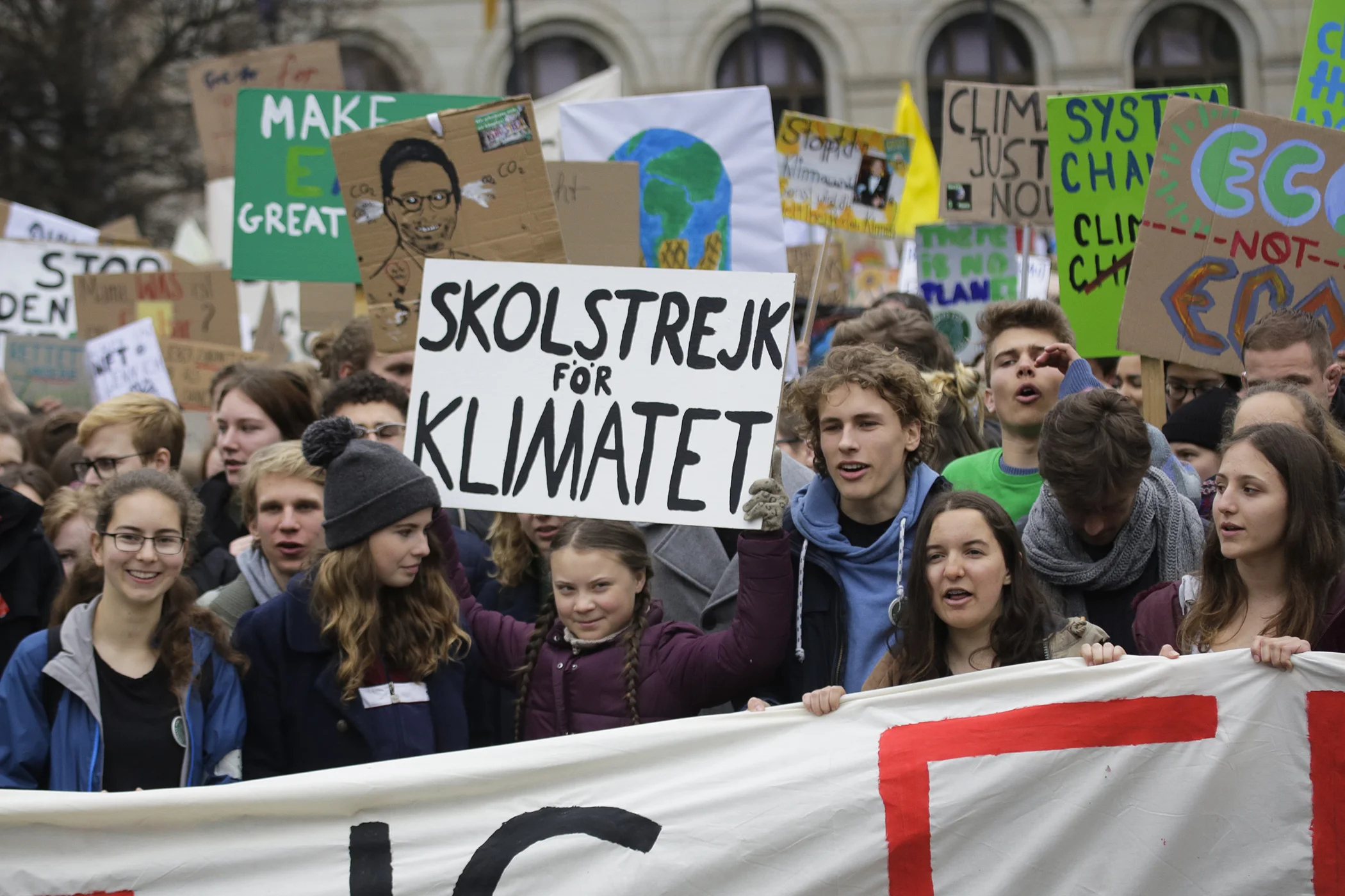 Swedish climate activist Greta Thunberg, center, lifts her sign which reads 'school strike for the climate'  as she attends the 'Friday For Future' rally in Berlin, Germany on March 29, 2019.
