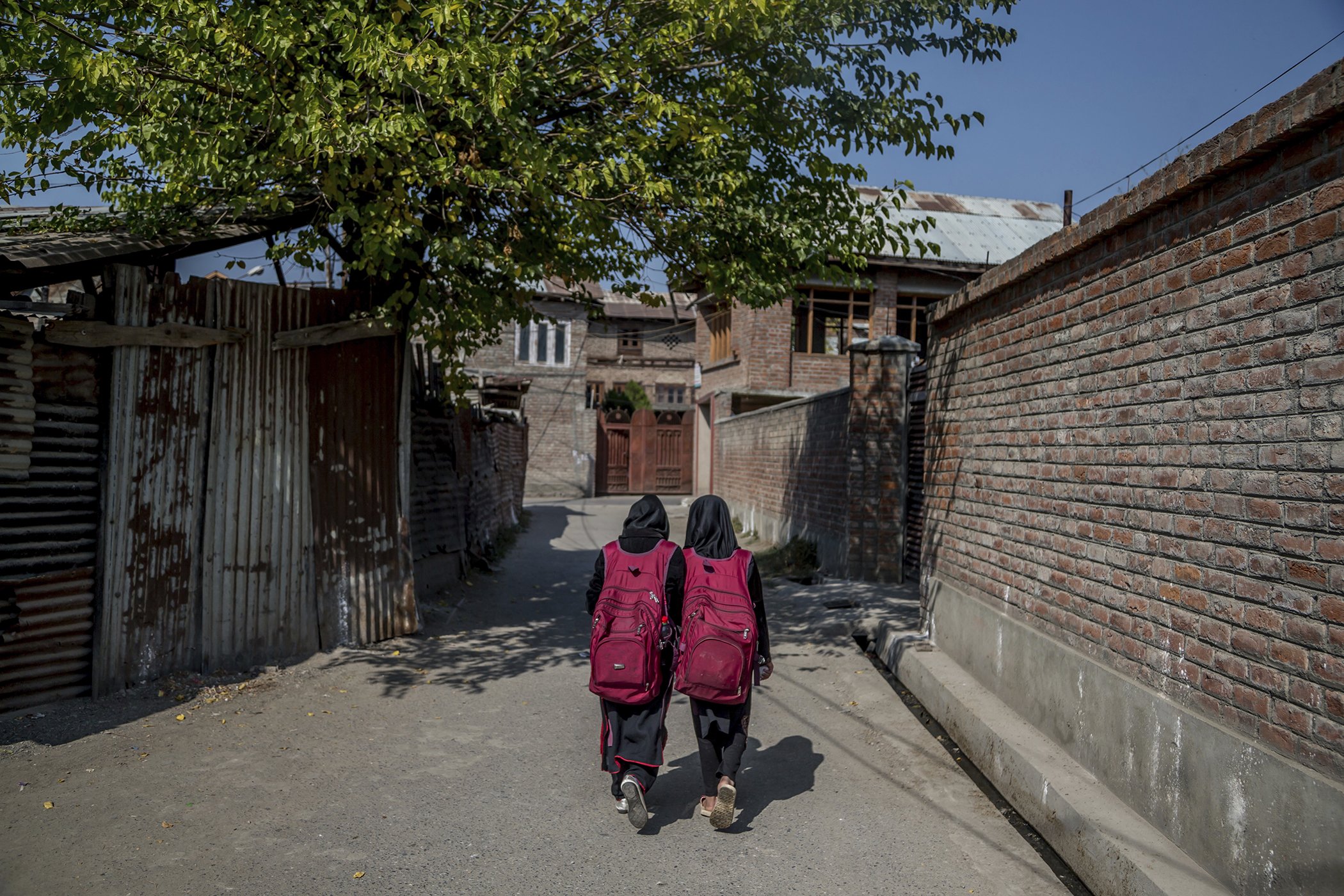 Two girls walk back home after attending an ad-hoc learning center set up in a local mosque in Srinagar, Indian controlled Kashmir on Oct. 20, 2016.
