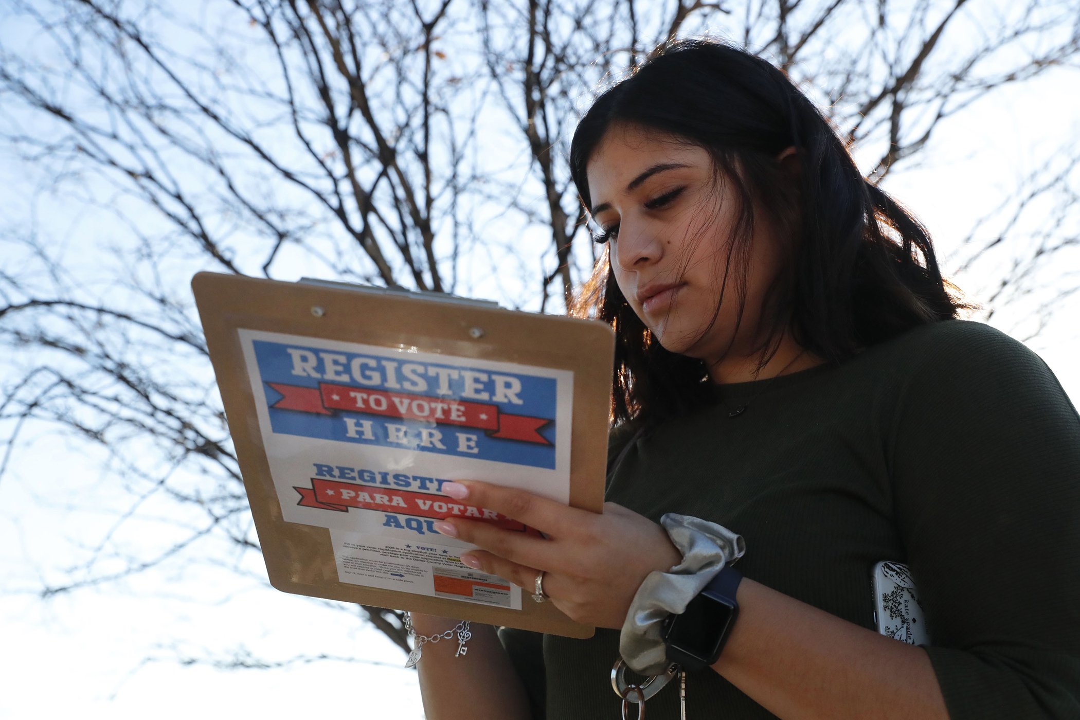 Karina Shumate, 21, a college student, fills out a voter registration form in Richardson, Texas, Jan. 18, 2020.