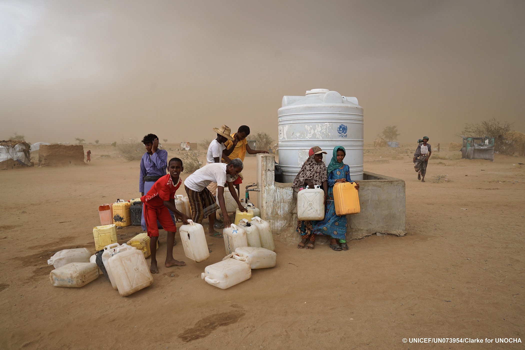 Internally displaced persons (IDPs) collect water as a sandstorm approaches in Abs IDP settlement, Hajjah Governorate, Yemen, in May 2017.