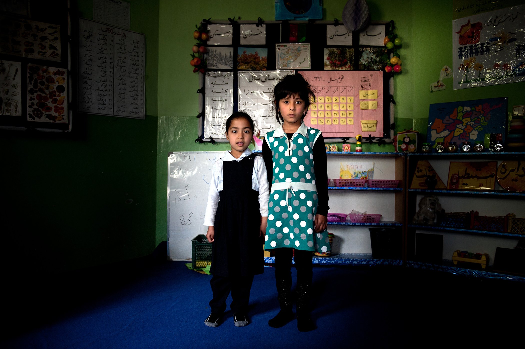 Two girls, both 5, stand in a day care centre in Kabul, Afghanistan. The girl on the left suffers from stunting.