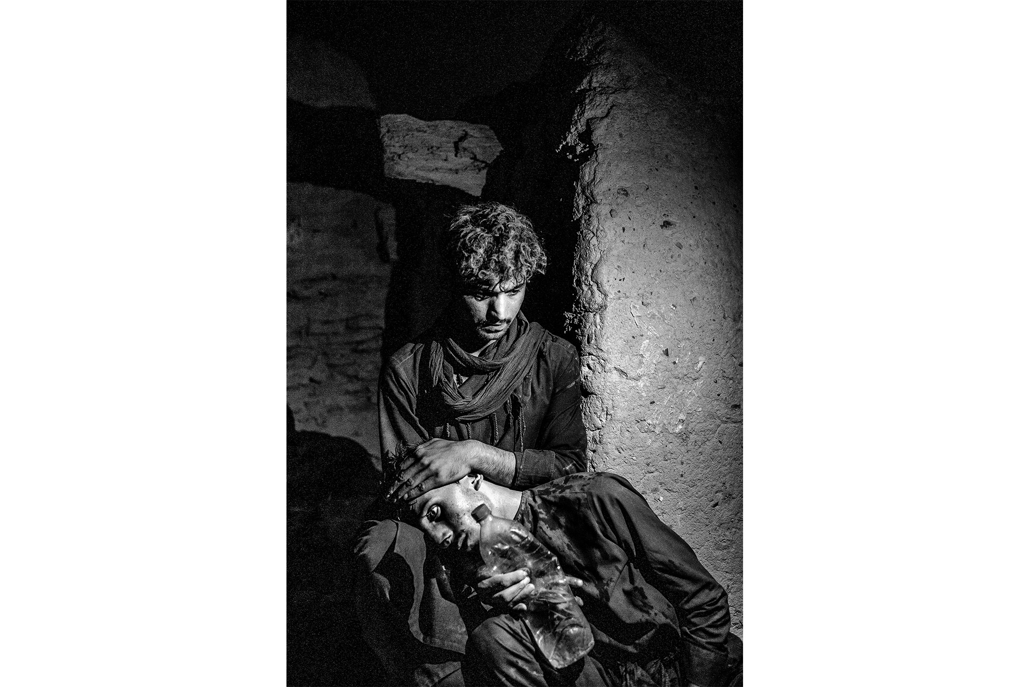 Afghan Refugees Waiting to Cross the Iranian Border: An Afghan refugee comforts his companion while waiting for transport across the eastern border of Iran, on July 27. Nominated in the Contemporary Issues Singles category.
