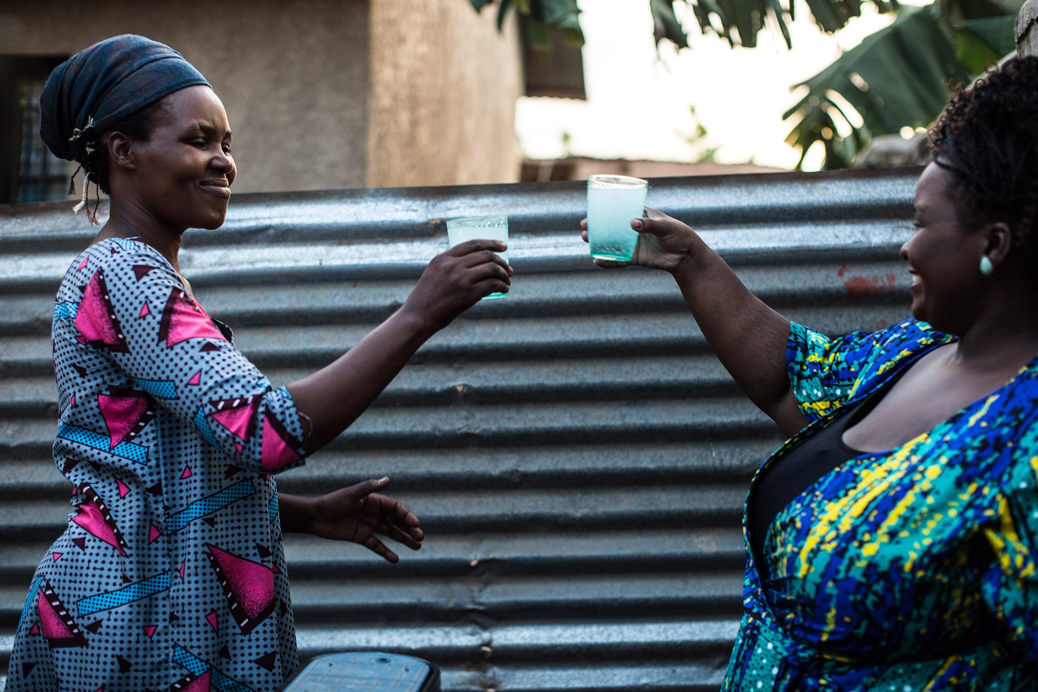 Regine Nyiransabimana, left, and Christelle Kwizera enjoy a glass of water. Kwizera made sure that the water her company supplies is affordable for everyone and charges just but it is $1 for 1,000L access to water.