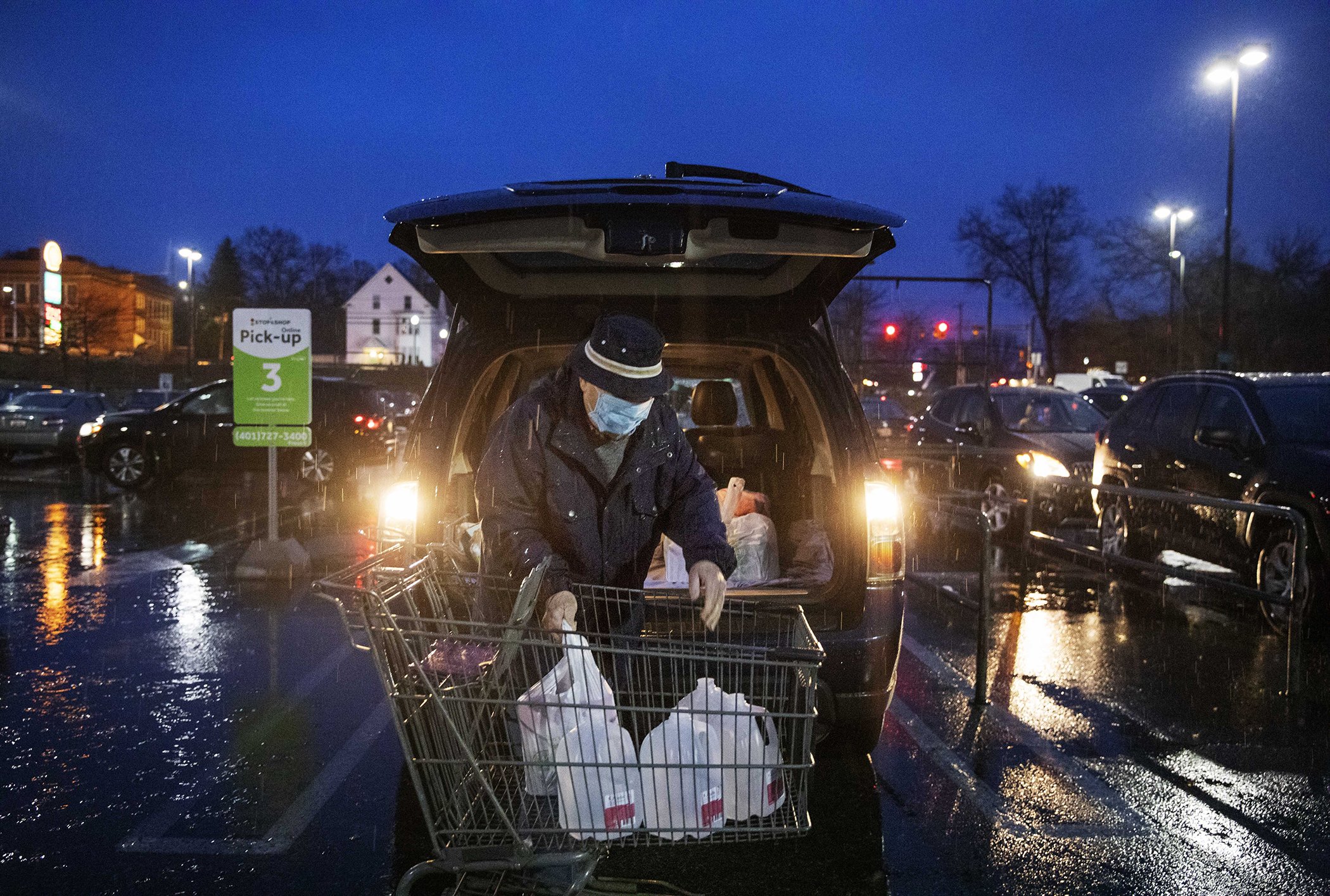 Don Gregson, 81, loads what was left of distilled water jugs into his car after shopping at a Stop & Shop supermarket during hours open daily only for seniors Thursday, March 19, 2020, in North Providence, R.I.