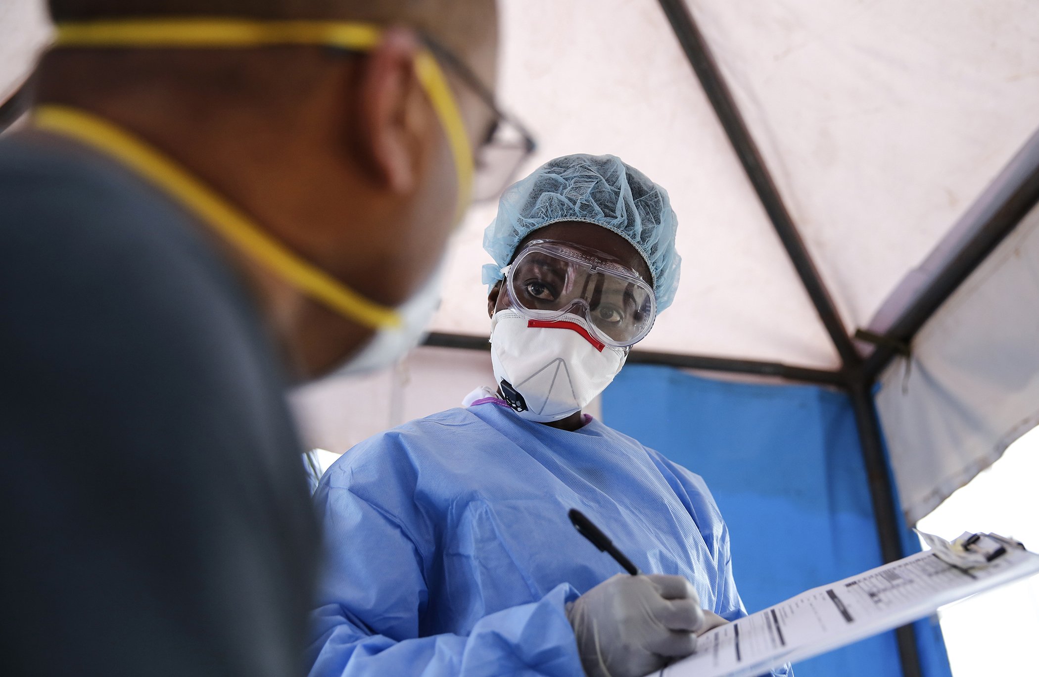 Laboratory technician Irene Ooko attends to a patient seeking a test for the new coronavirus that causes COVID-19, at the Pathologists Lancet Kenya laboratory in Nairobi, Kenya on April 5, 2020.