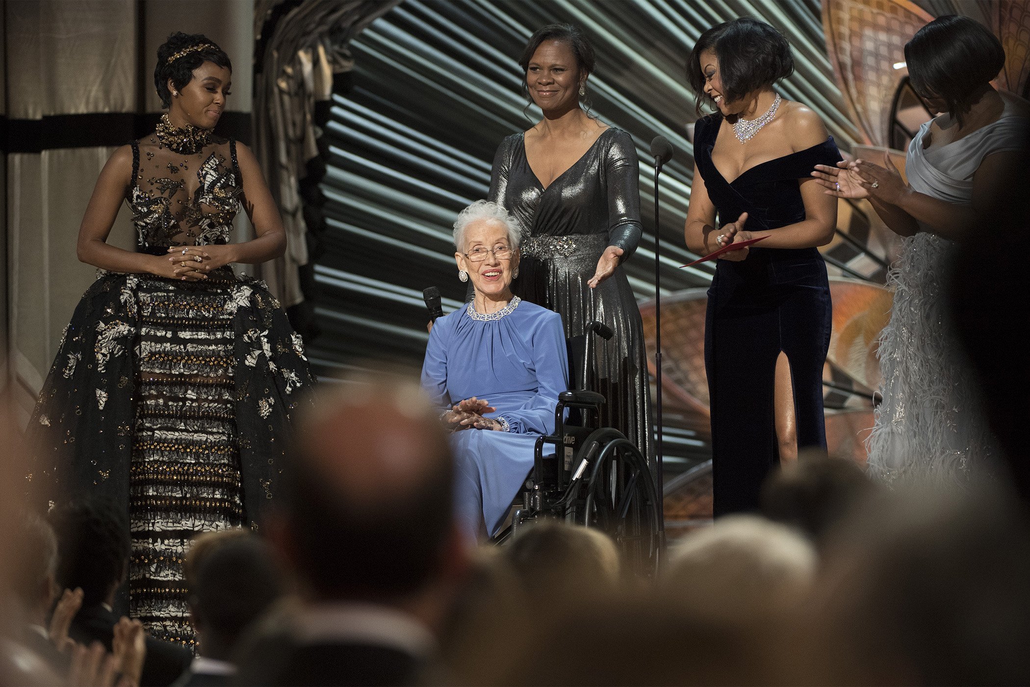 Janelle Monae, left, Taraji P. Henson, second right and Octavia Spencer, right, introduce Katherine Johnson, seated, as they present the award for best documentary feature at the Oscars at the Dolby Theatre in Los Angeles, Calif., on Feb. 26, 2017.