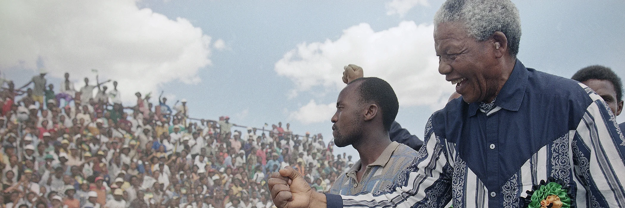 African National Congress President Nelson Mandela salutes the crowd in Galeshewe Stadium near Kimberley, South Africa, before a forum on Feb. 25, 1994.