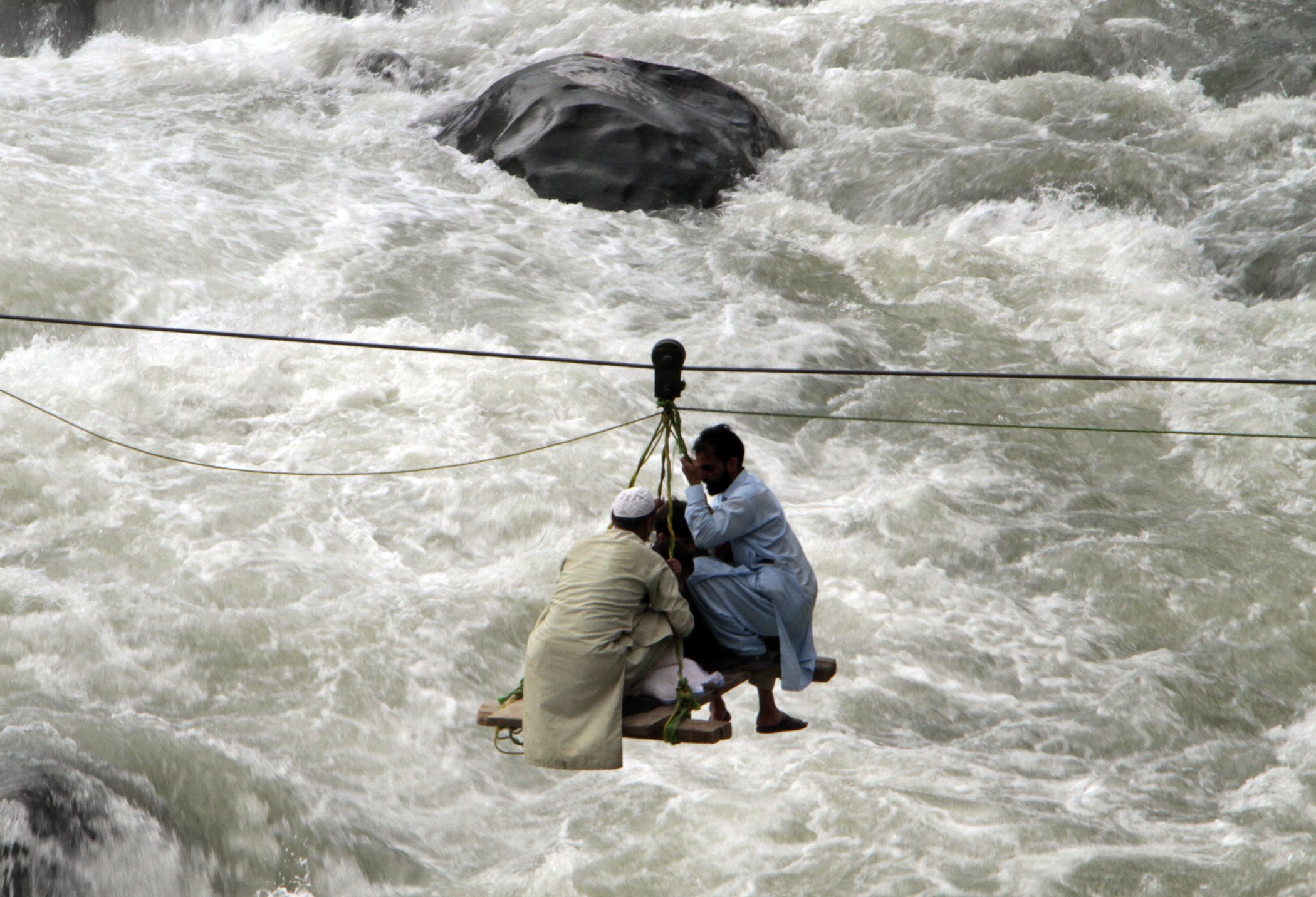 People cross a river on a suspended cradle in Bahrain, Pakistan, Aug. 30, 2022. The UN and Pakistan issued an appeal for $160M in emergency funding to help millions affected by floods that have killed more than 1,150 people since mid-June. People cross a river on a suspended cradle, in the town of Bahrain, Pakistan, Aug. 30, 2022.