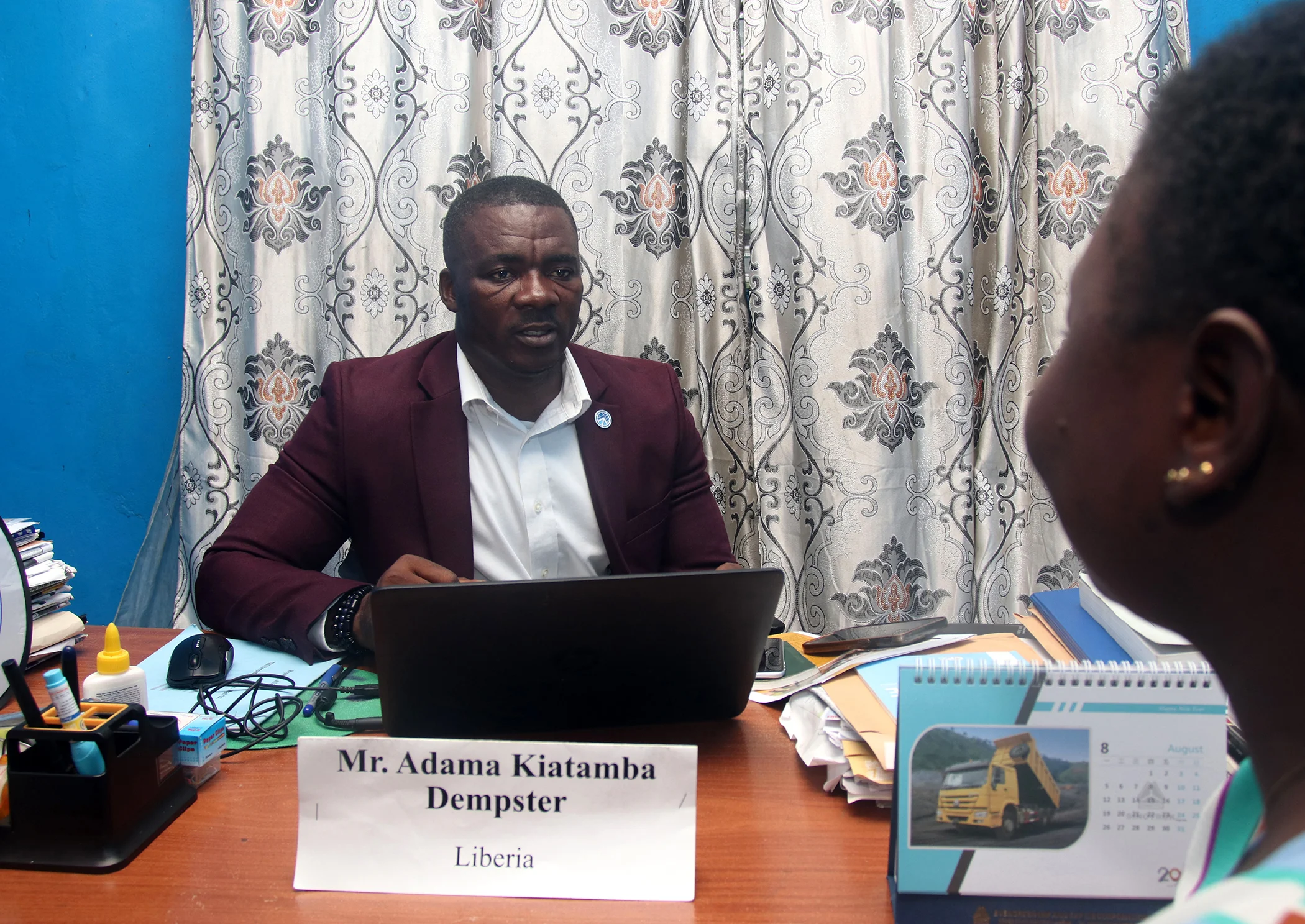 Adama Kiatamba Dempster (L) speaks with a staff member at his office in Congo town, outside Monrovia, Liberia on Aug. 13, 2024.
