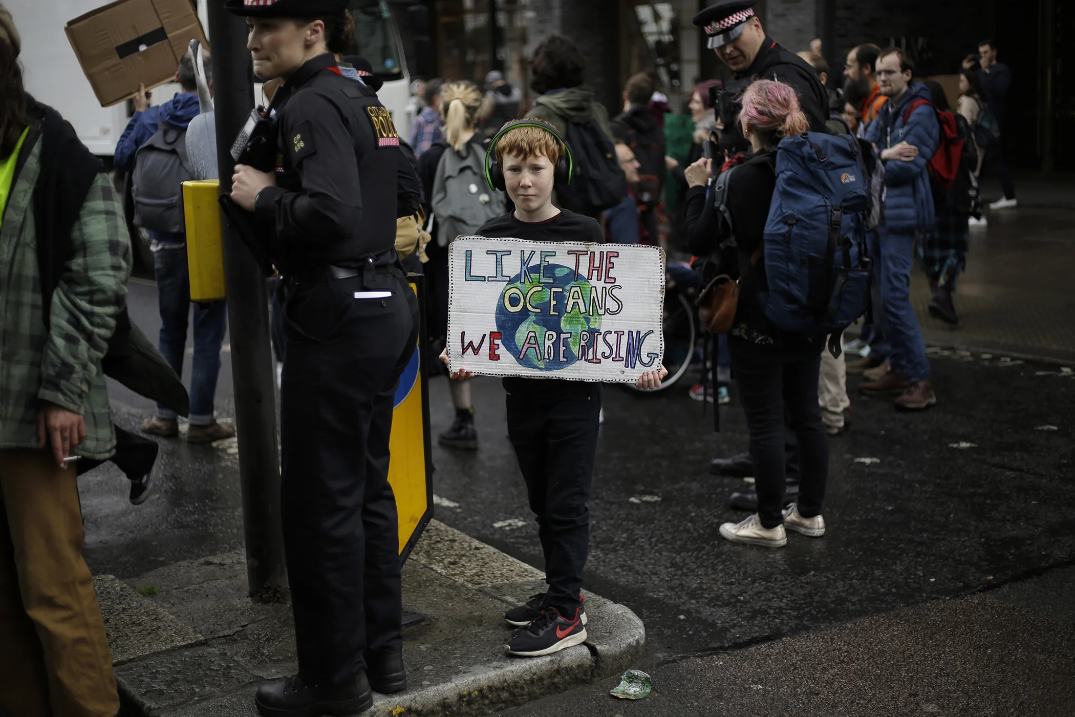 A young Extinction Rebellion climate change protester holds a banner as they briefly block a road in central London, Wednesday, April 24, 2019.