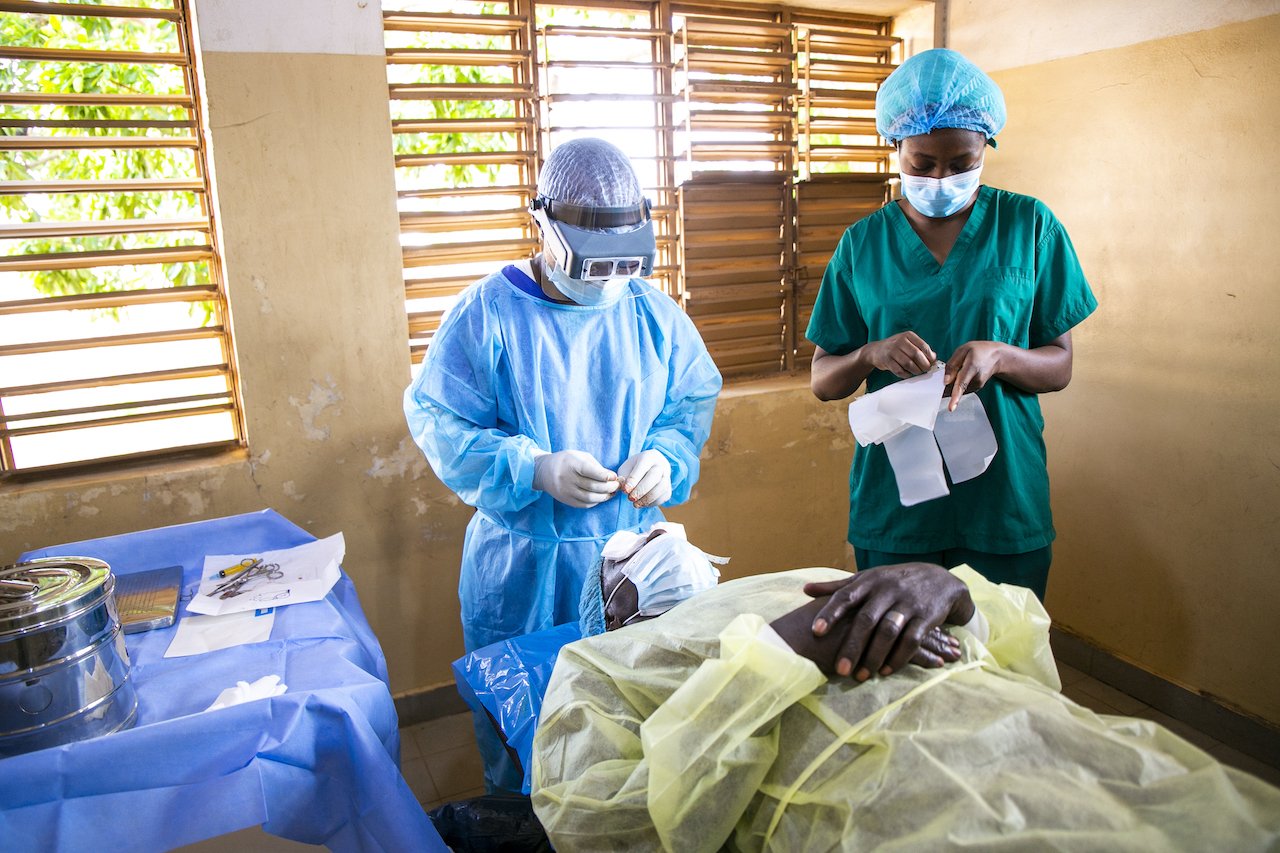 Surgeon, Raphael Agbotchotcho, is bandaging Fousseni Seko Sembere's eyes following his surgery. Helped by nurse Taibatou Abdou.