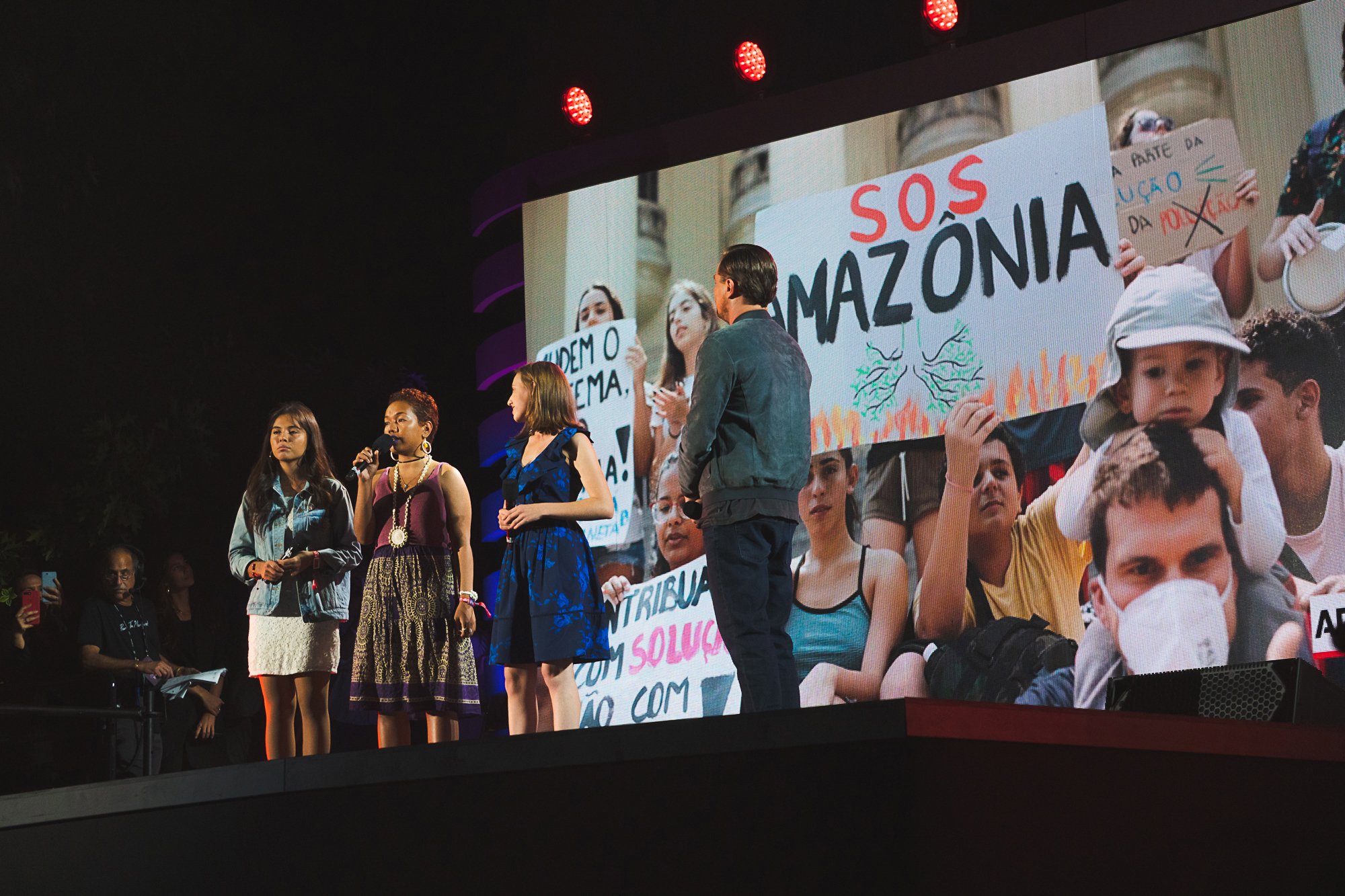 Climate activists Xiye Bastida, Selina Neirok Leem, Alexandria Villaseñor speak on stage as Leonardo DiCaprio listens during the Global Citizen Festival on Sept. 28, 2019, in New York City.