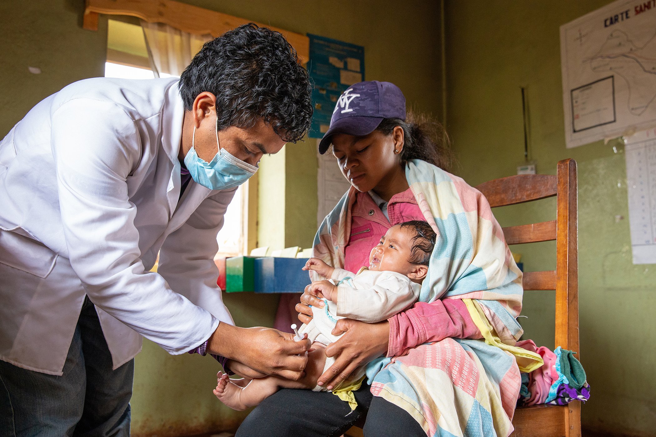 A mother holds her young child at the health center of Soamanandrariny, a rural community in Madagascar, to receive maternal and child health care services in December 2020.