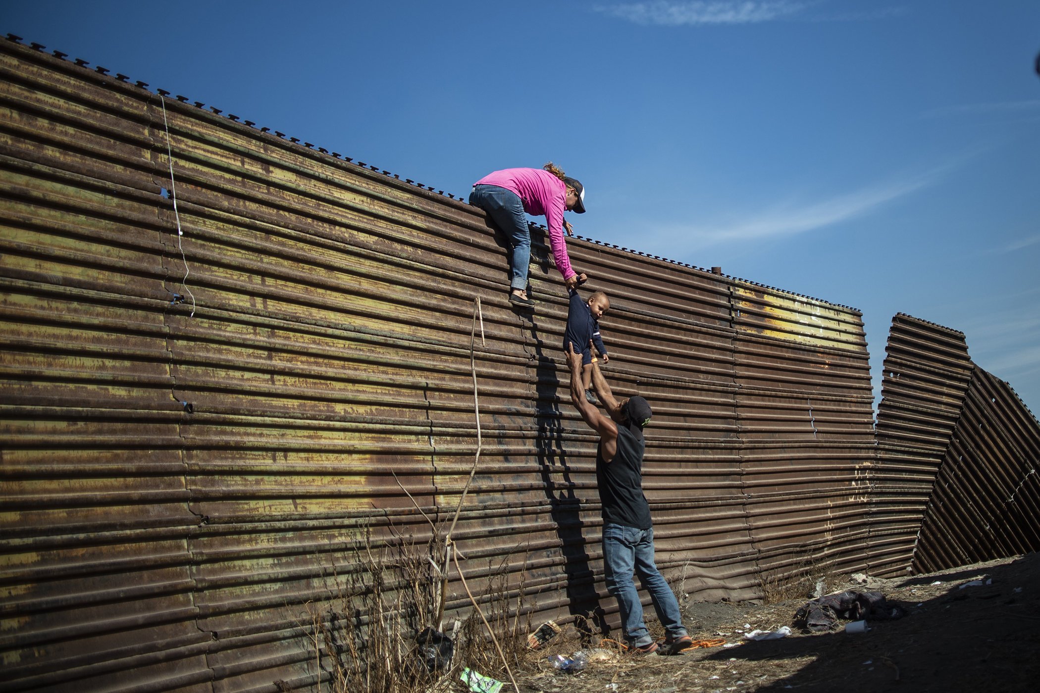 Climbing the Border Fence: Central American migrants climb the border fence between Mexico and the United States, near El Chaparral border crossing, Tijuana, Baja California, Mexico, on Nov. 25, 2018. Nominated in the Spot News Singles category.