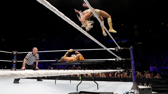 Charlotte Flair showcases her incredible athleticism while executing her signature moonsault off the top rope.