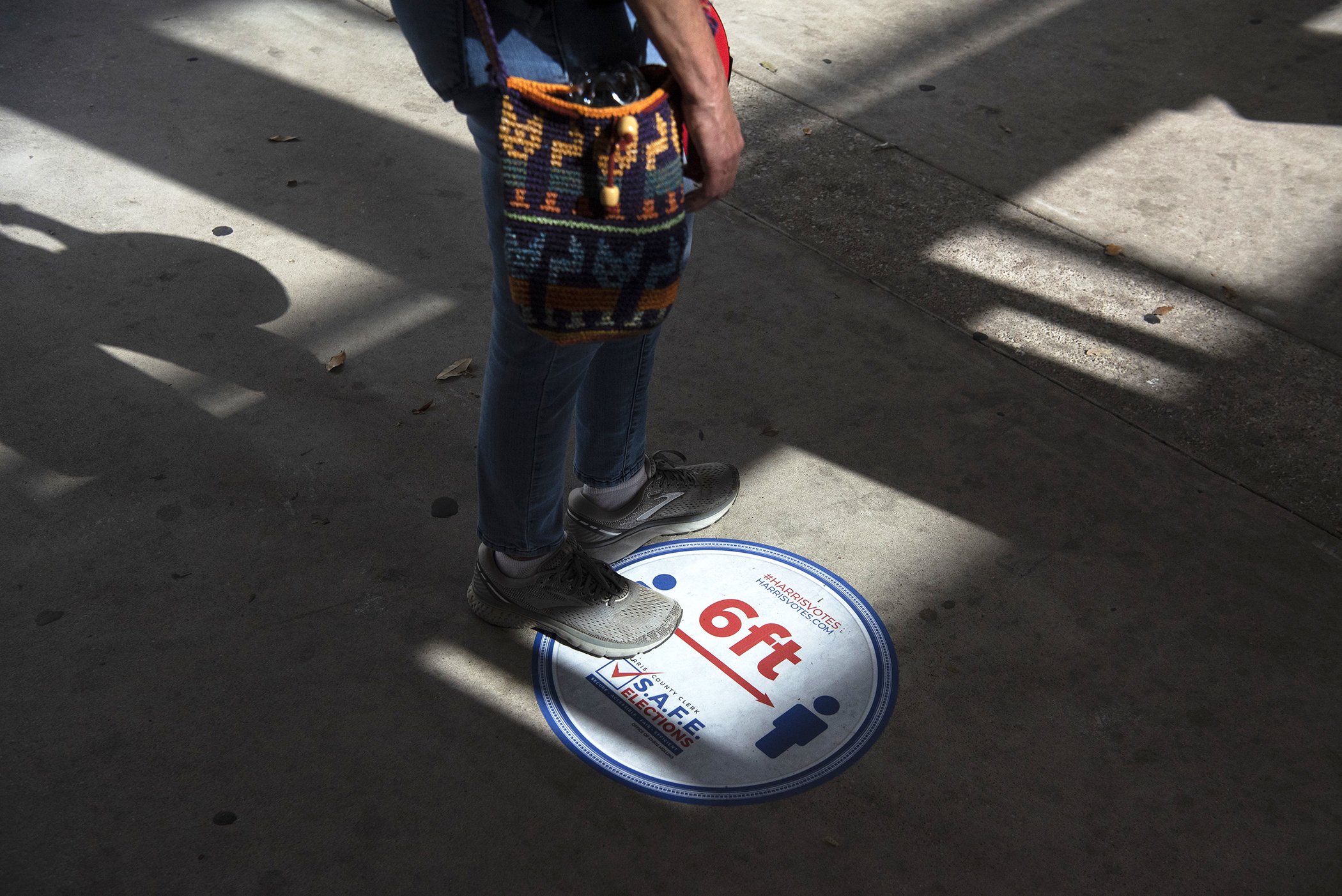 A voter stands in line on a social distancing marker while waiting to cast a ballot at an early voting polling location for the 2020 Presidential elections in Houston, Texas, Oct. 13, 2020.