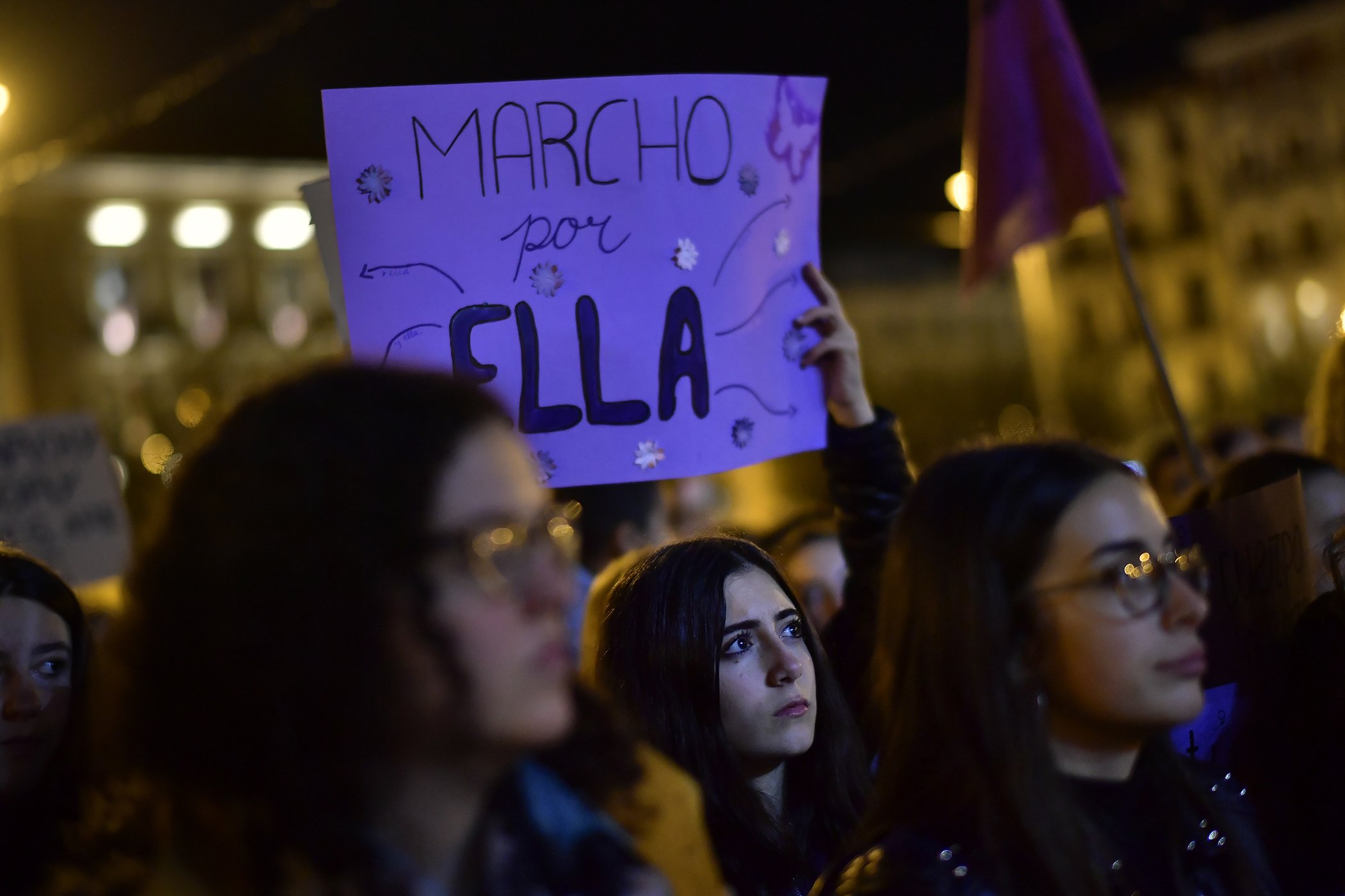 A woman holds a banner reading ''I march for Her'', during a protest against male violence against women in Pamplona, northern Spain, Nov. 25, 2019, on the UN's International Day for the Elimination of Violence against Women.