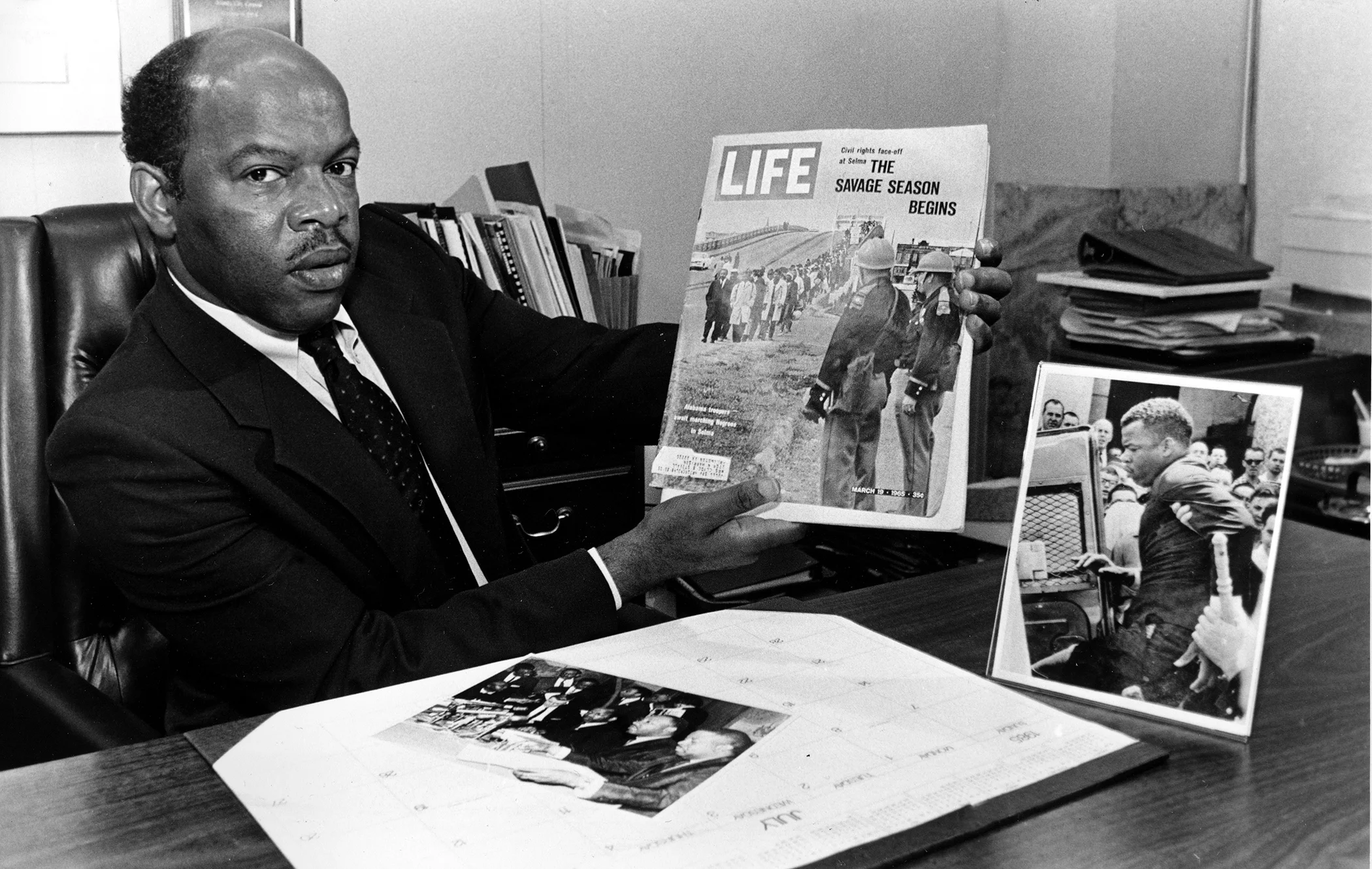 Then Atlanta City Councilman John Lewis holds the March 1965 issue of Life Magazine in his office in Atlanta, Georgia, in August 1986. The cover photo shows Lewis leading the first Selma, Alabama, civil rights march with Hosea Williams.