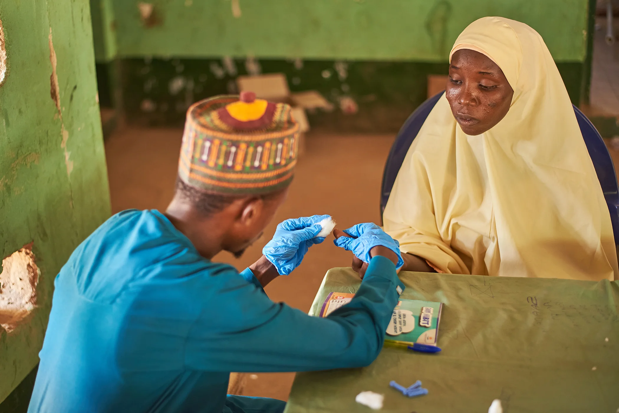 Jabir Adamu, a community case worker for Project HOPE, conducts an HIV test on pregnant mother Aisha Aliyu at Maternal and Child Health (MCH) Primary Health Center in Nassarawa, Kebbi state, Nigeria.