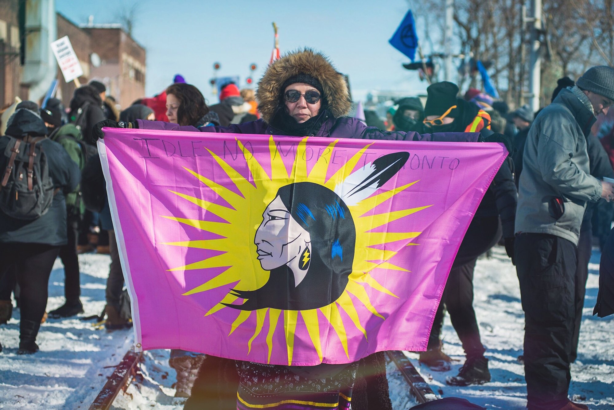 An attendee in parka holds a flag at a Wet'suwet'en Solidarity Event at Dufferin Street and Bartlett Avenue in Toronto on Feb. 8, 2020.