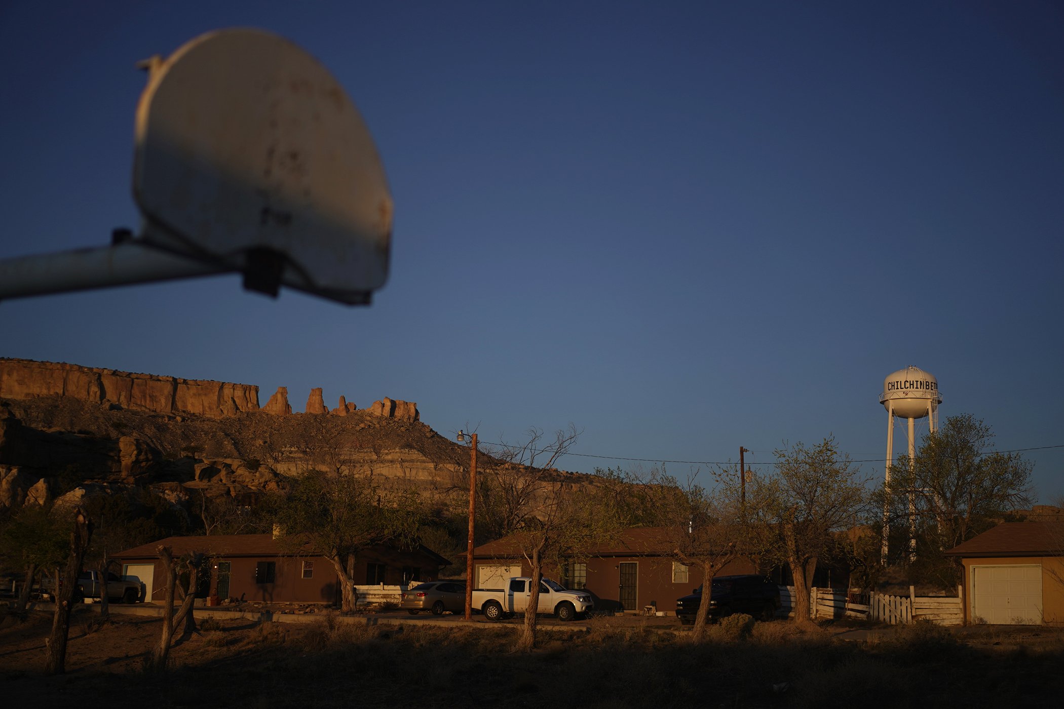 The water tower and a basketball backboard at the school in Chilchinbeto, Ariz., on the Navajo reservation, are seen at sunrise on April 19, 2020.