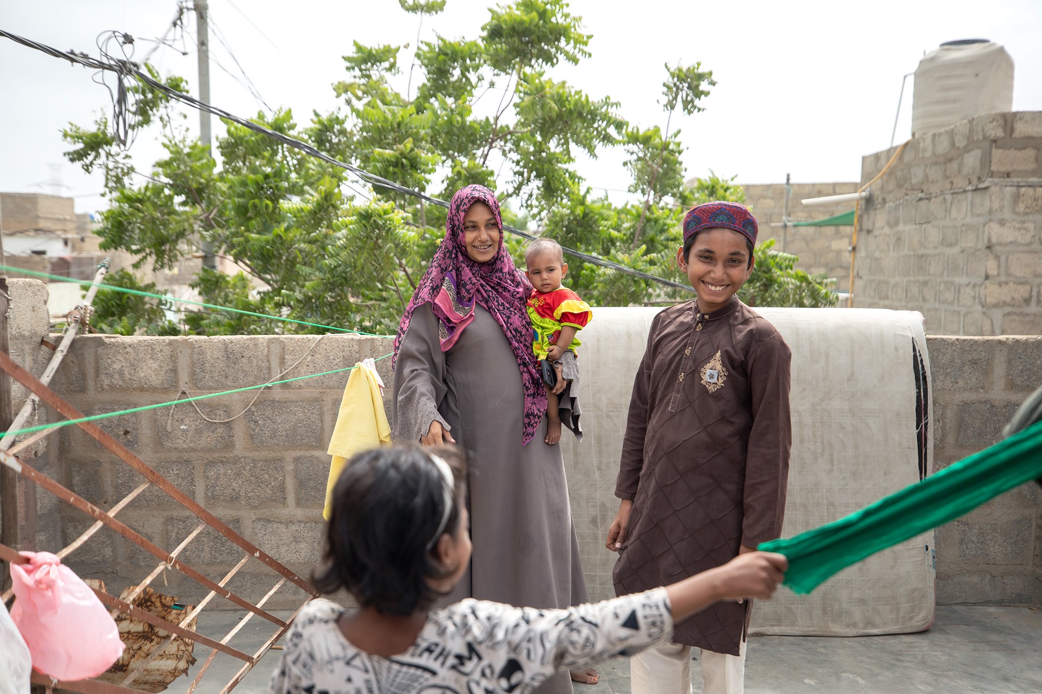 Sana, 29, plays with her five children at a community mobilizer's home in their neighborhood in Karachi, Pakistan on July 30, 2025.