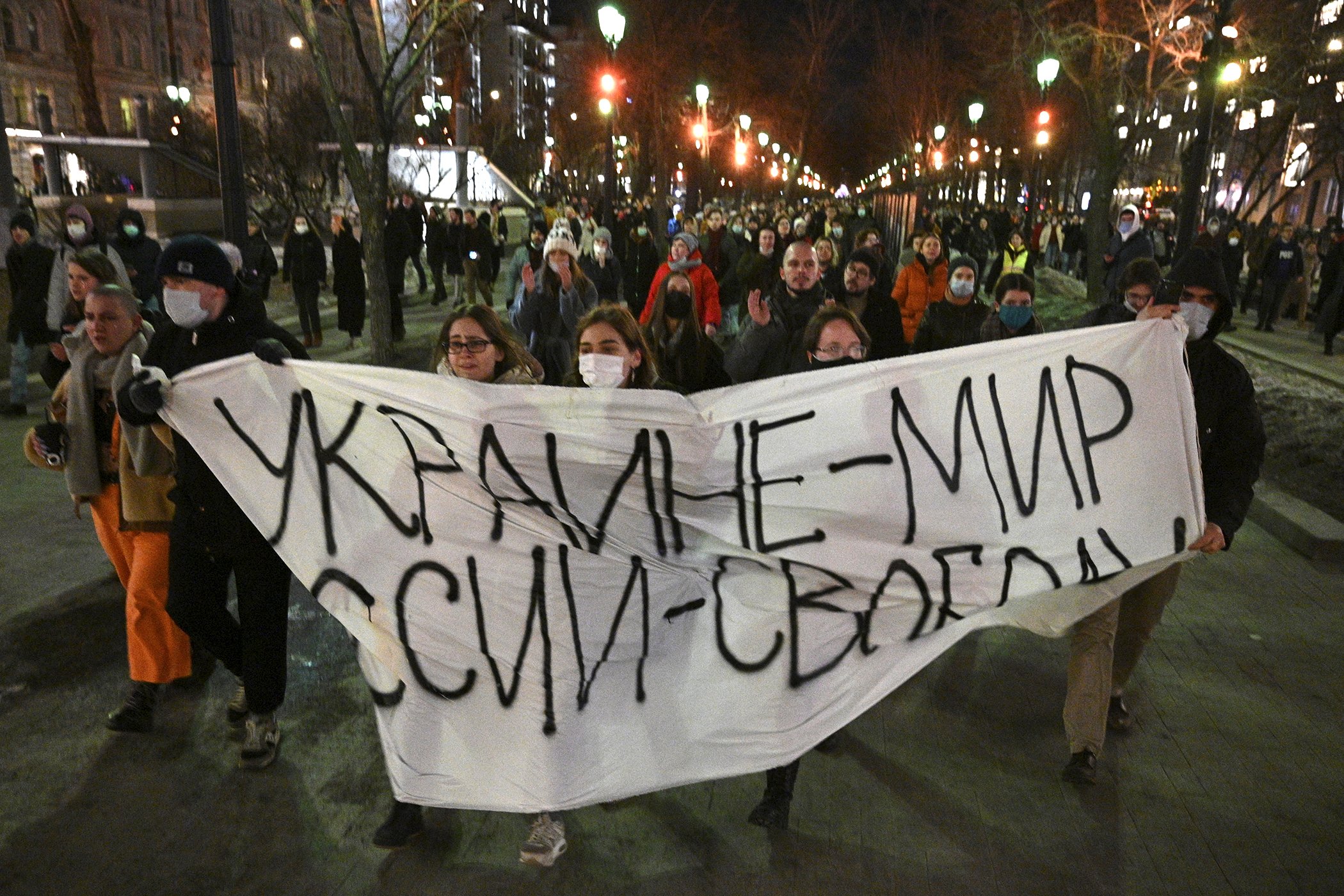 Demonstrators march with a banner that reads: "Ukraine - Peace, Russia - Freedom", in Moscow, Russia, Feb. 24, 2022. Hundreds of people gathered in the center of Moscow on Thursday, protesting against Russia's attack on Ukraine.