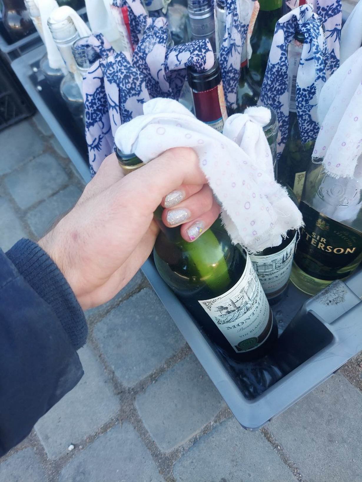 Dmytro, a 23-year-old non-binary translator from Bila Tserkva, holds a Molotov cocktail while they show their sparkly white glitter fingernails while serving at the Ukrainian territorial defence forces.