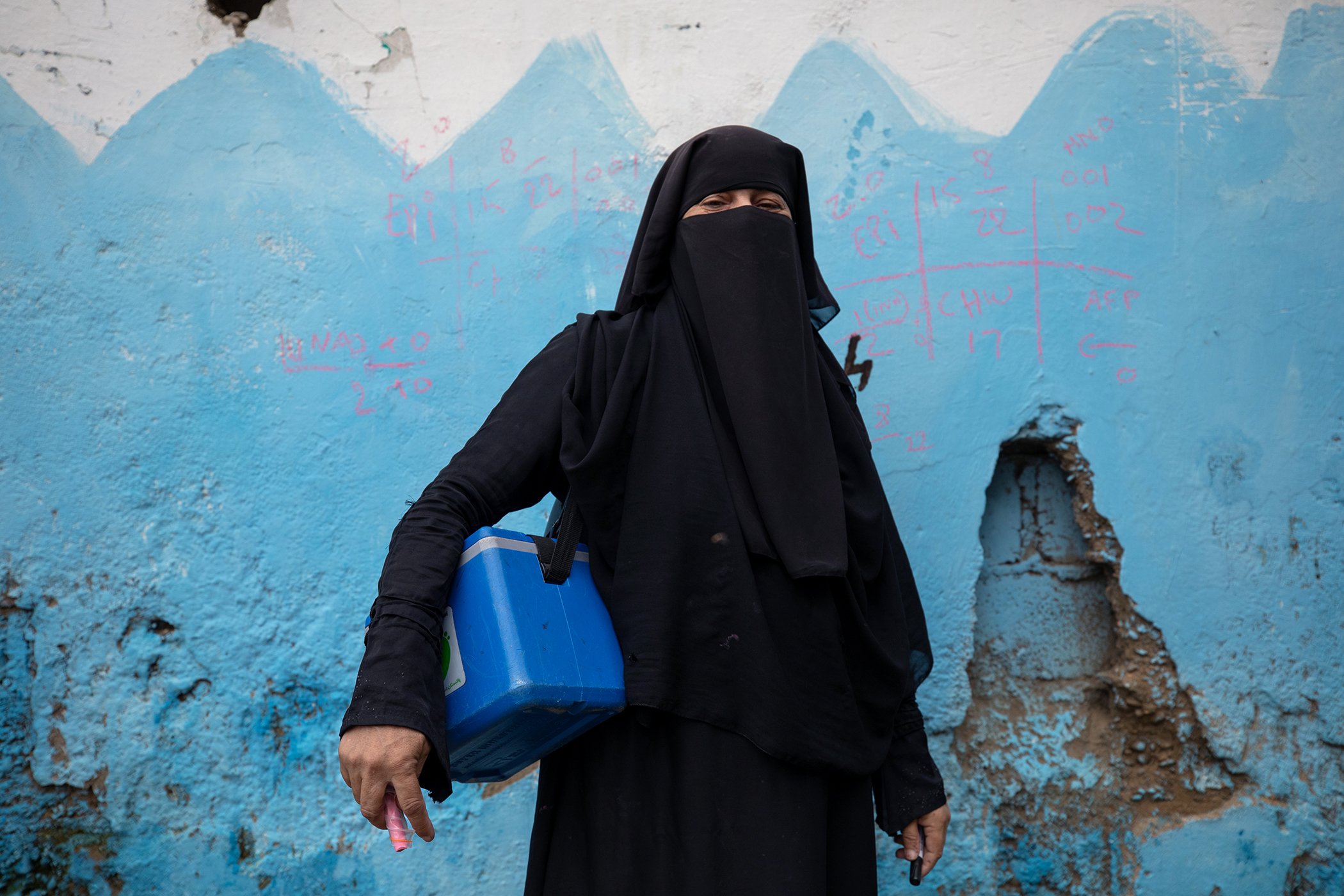 A polio vaccinator goes door to door to vaccinate children in Sultanabad, Karachi, Pakistan on Aug. 21, 2022.