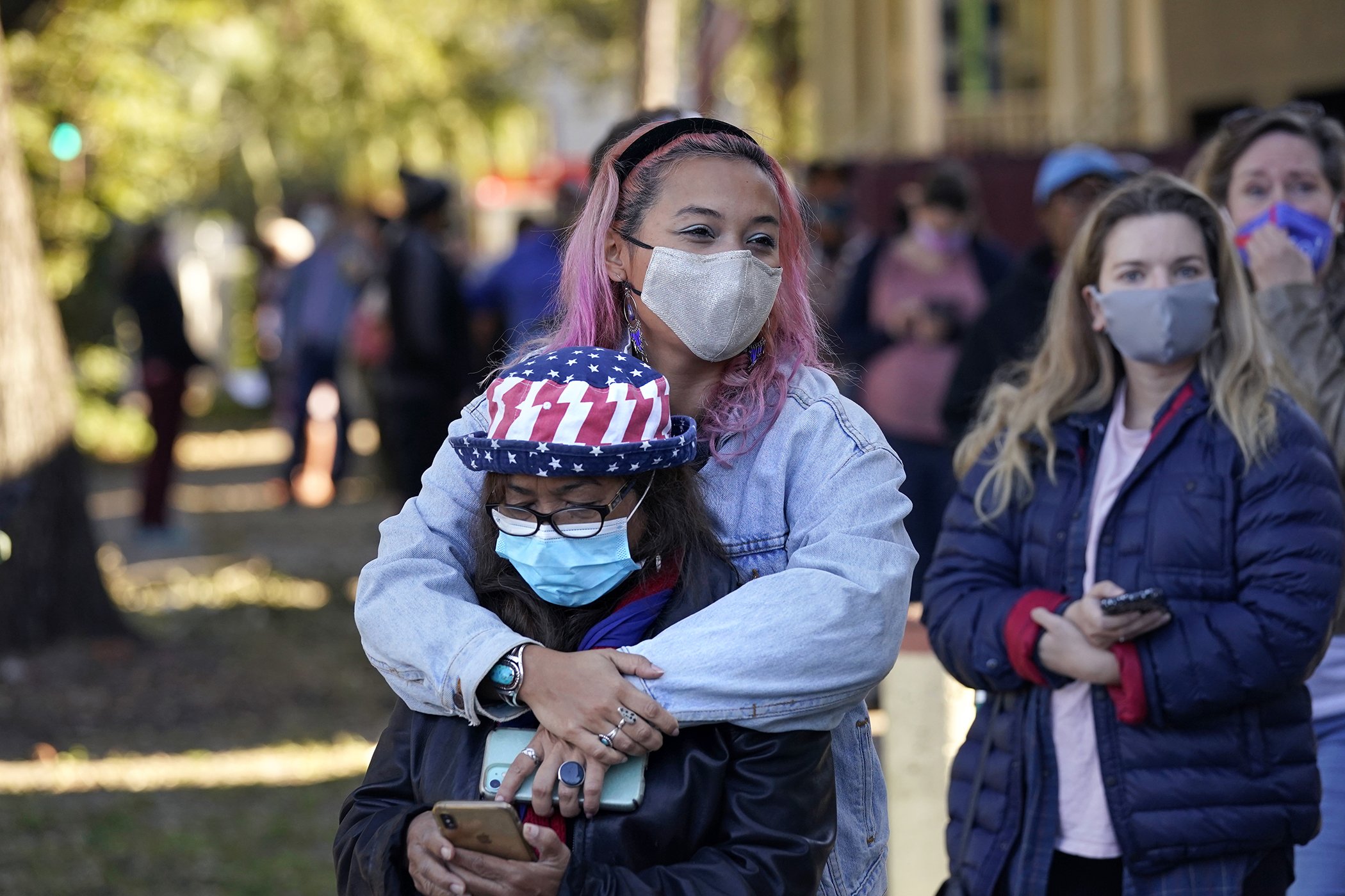 Erin Doherty hugs her mother Susanna Dew, 61, who is voting for the first time in her life, as they wait in line at a polling place on election day in the Mid City section of New Orleans, Nov. 3, 2020.