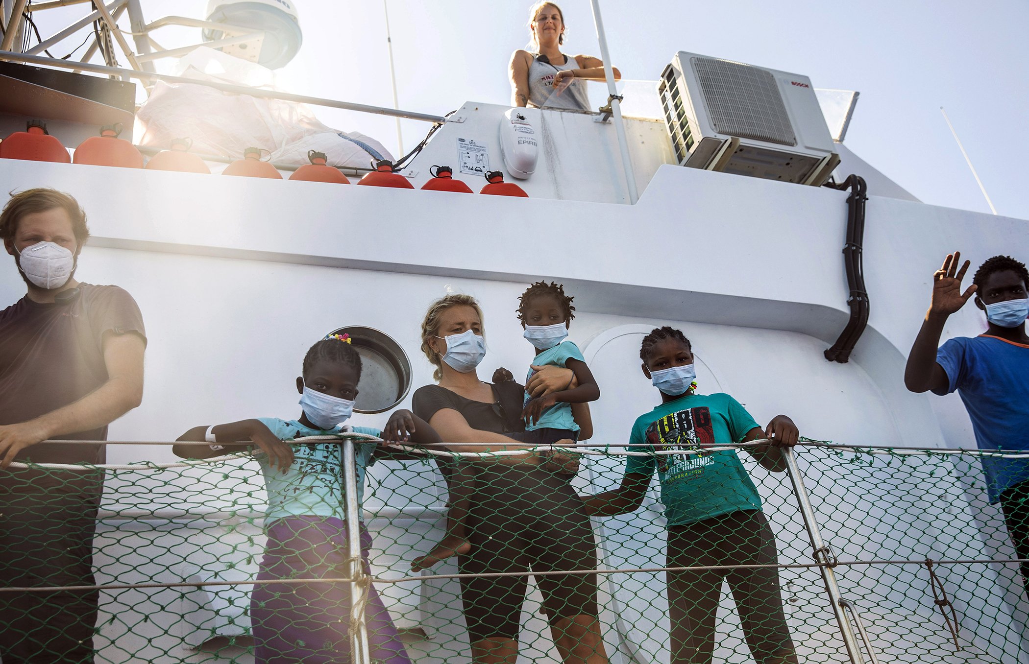 A group stands on the deck of the Louise Michel in the Mediterranean sea, Aug. 28, 2020. The group operating the vessel, named after a 19th century French feminist and anarchist, said late Thursday that it rescued 89 from an inflatable boat in distress.
