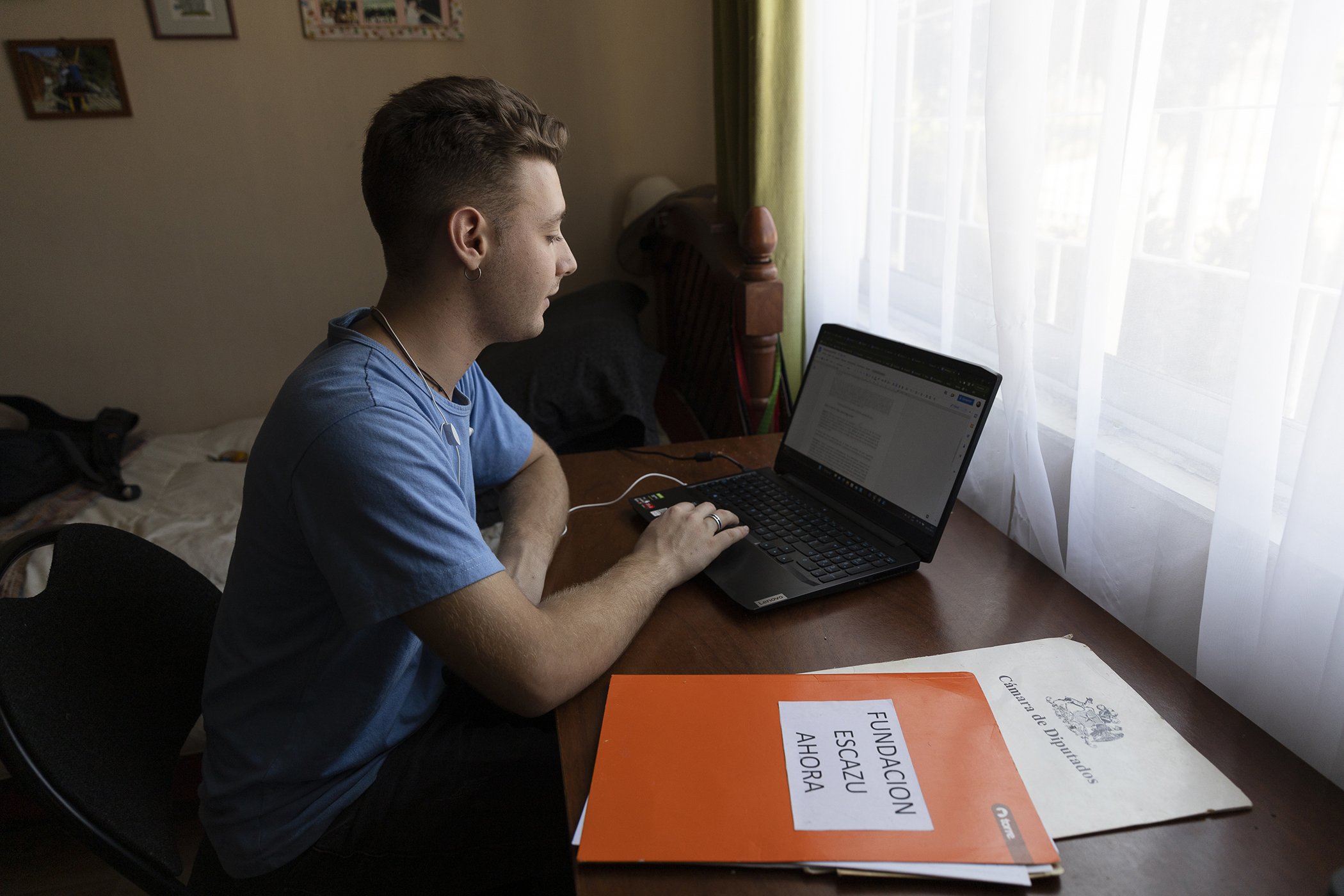 Sebastián Benfeld works at his computer in his room in Quilpué, Valparaíso region, in Chile on Feb. 20, 2023. Benfeld is part of the Escazú Ahora organization.