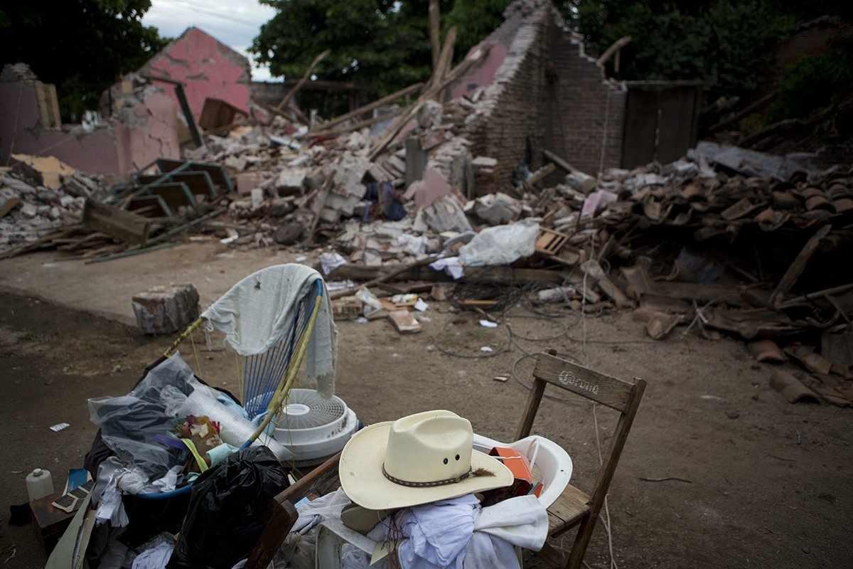 A handful of salvaged items sit in front of what remains of a home destroyed by Thursday's magnitude 8.1 earthquake, in Asuncion Ixtaltepec, Oaxaca state, Mexico, Sept. 10, 2017.