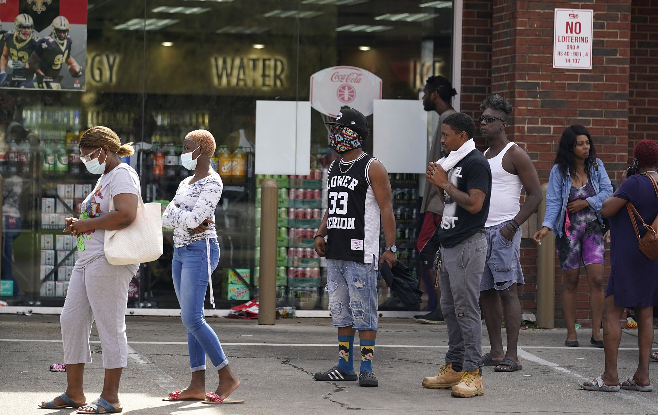 People wait in line at a convenience store, Aug. 31, 2021, in New Orleans. The effects of Hurricane Ida left New Orleans without power with the exception of those with generators.