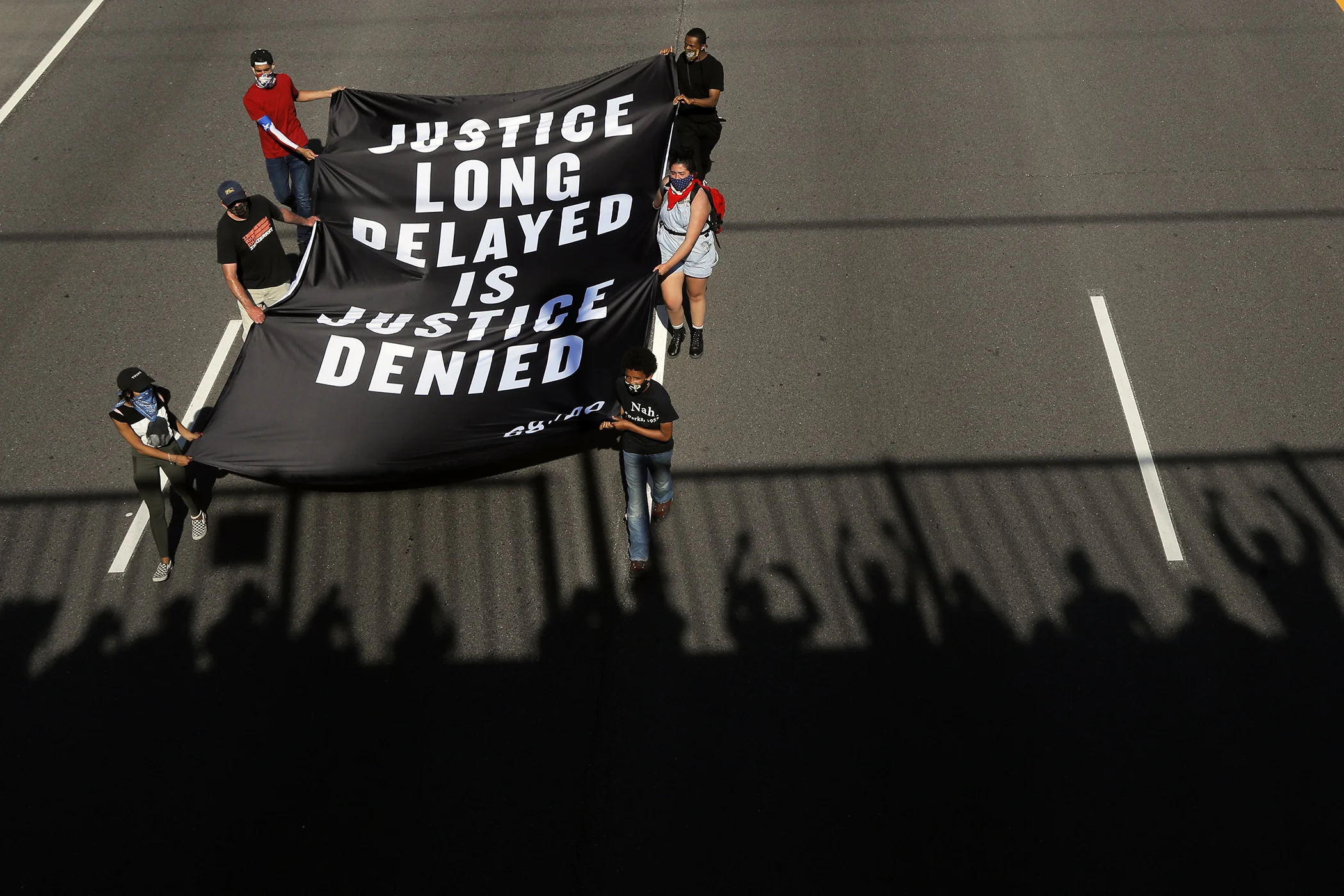Demonstrators march along an interstate highway Sunday, May 31, 2020, in Minneapolis.