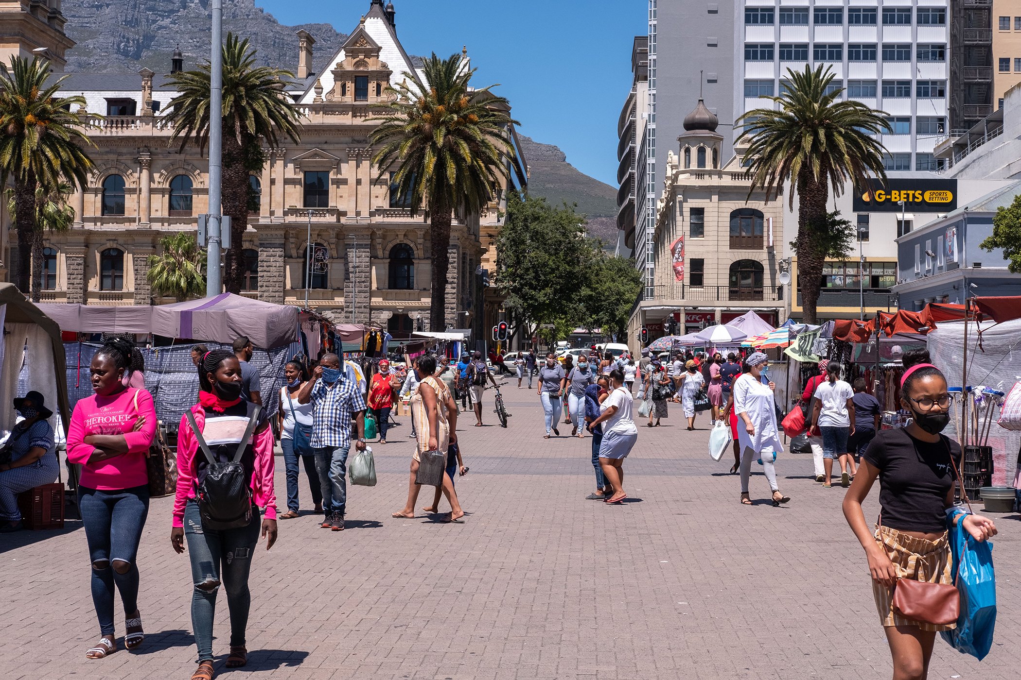 People pass through a market on Dec. 5, 2020 in Cape Town. In 2018, the World Bank recognized South Africa as one of the world's most unequal countries, where the top percentile of South Africans own 70.9% of the nation's wealth, according their report.