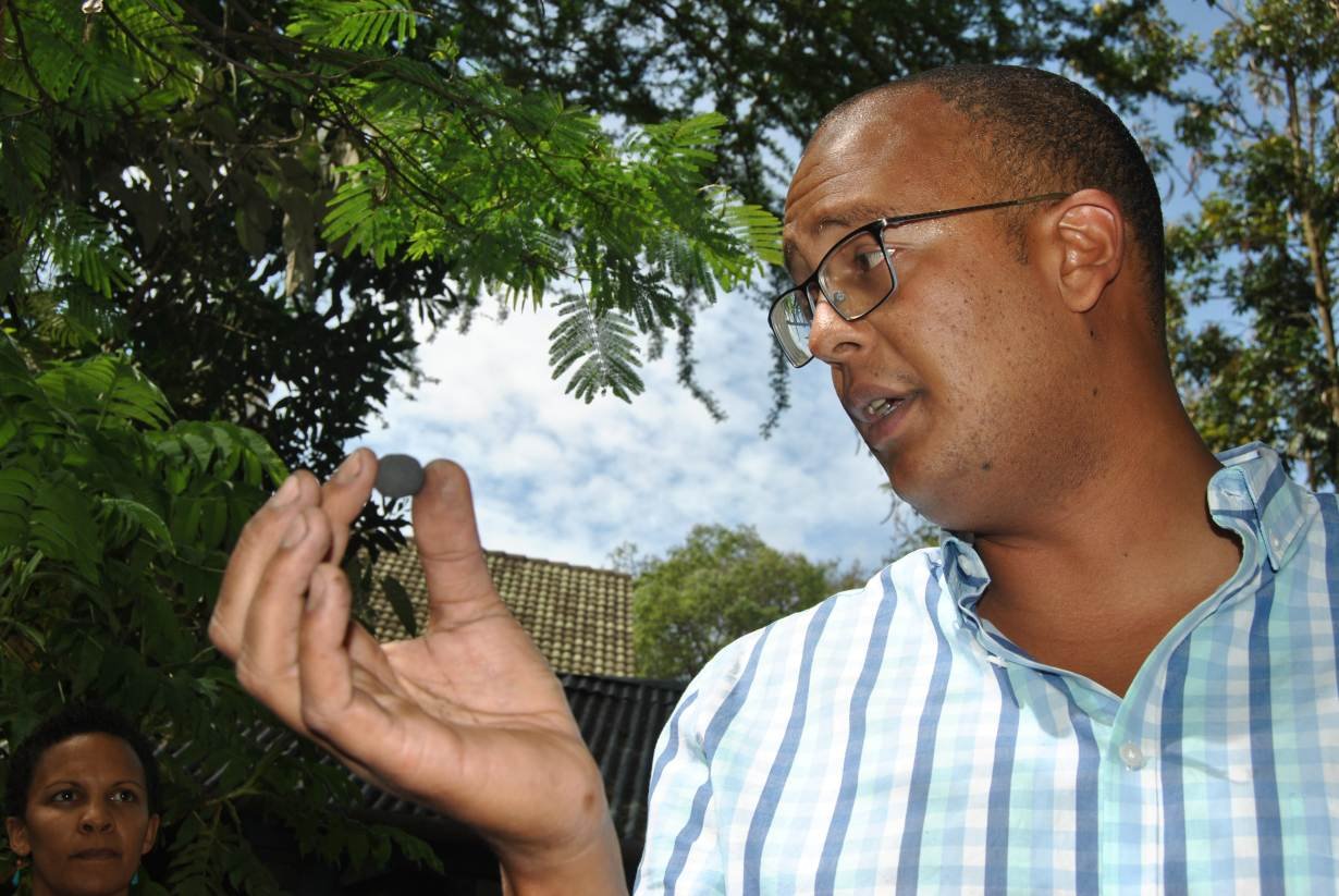 Teddy Kinyanjui holds one of the charcoal-dust-coated tree seedballs he manufactures at his home in Nairobi, Kenya, November 15, 2017.